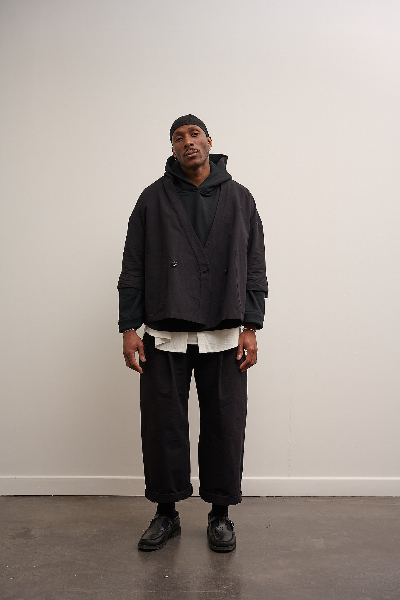 Veste croisée à col kimono de la marque Aïdama, modèle samue en mélange de coton et papier japonais noir. Portée ouverte par un mannequin homme et vu de face.