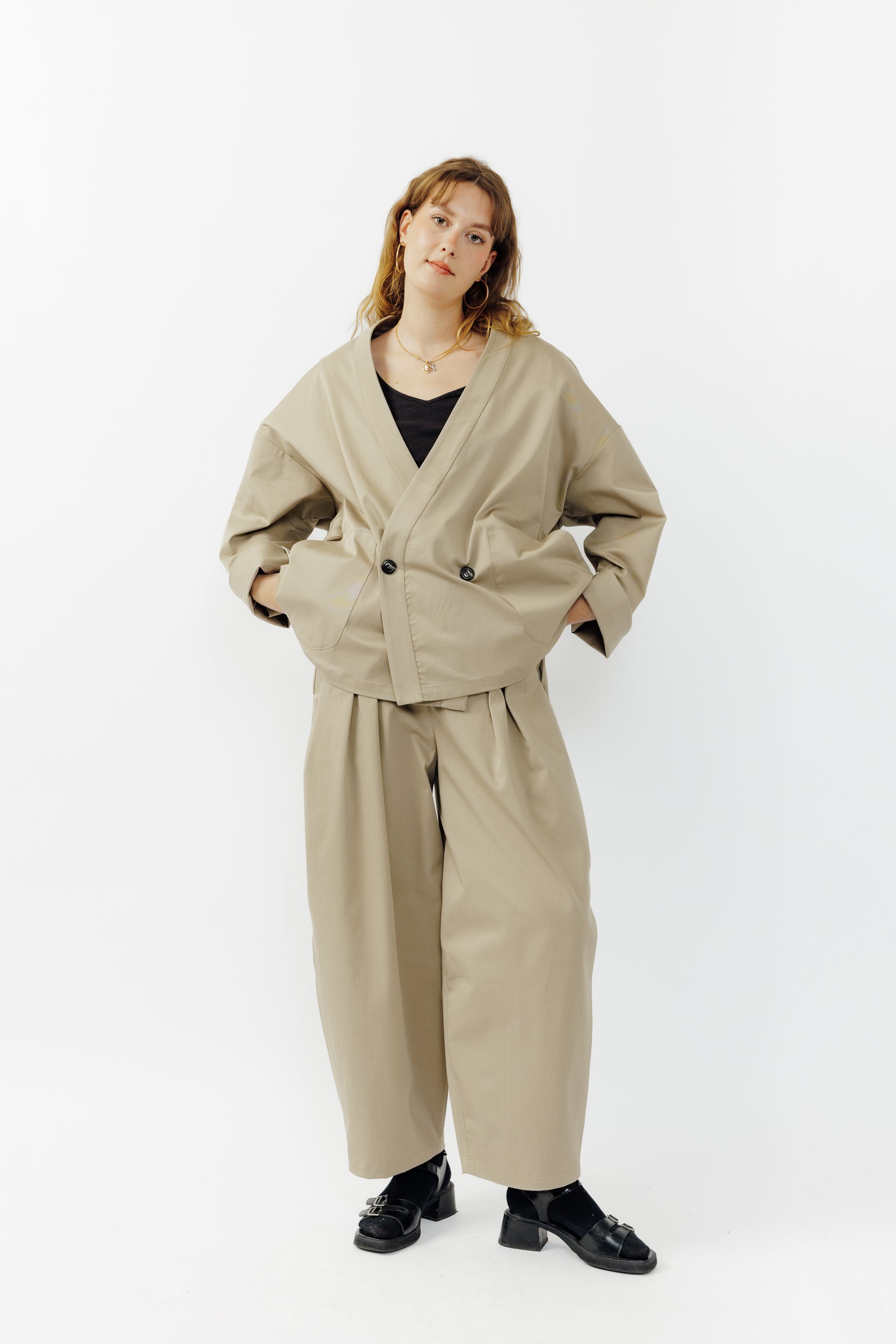 Veste croisée à col kimono de la marque Aïdama, modèle samue en gabardine de coton beige. Portée fermée par une mannequin femme et vu de face. 
