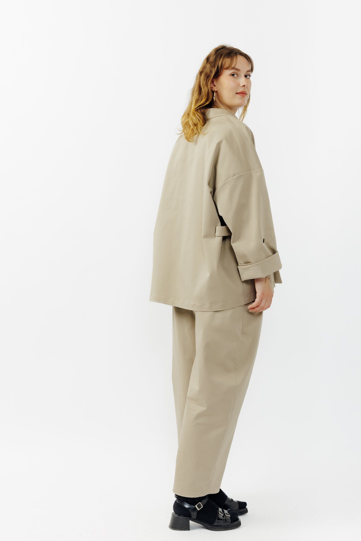 Veste croisée à col kimono de la marque Aïdama, modèle samue en gabardine de coton beige. Portée fermée par une mannequin femme et vu de dos.