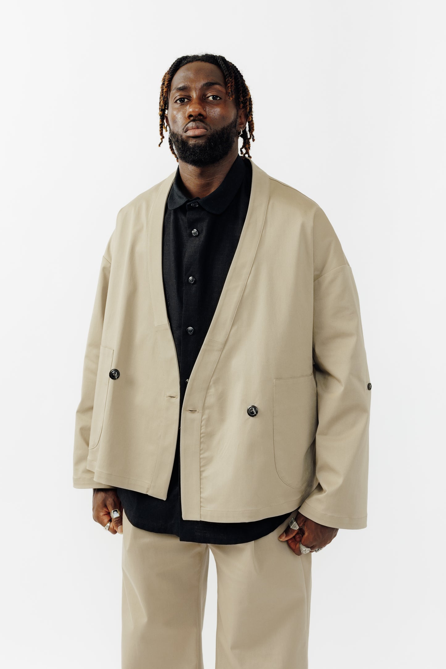 Veste croisée à col kimono de la marque Aïdama, modèle samue en gabardine de coton beige. Portée ouverte par un mannequin homme et vu de face.
