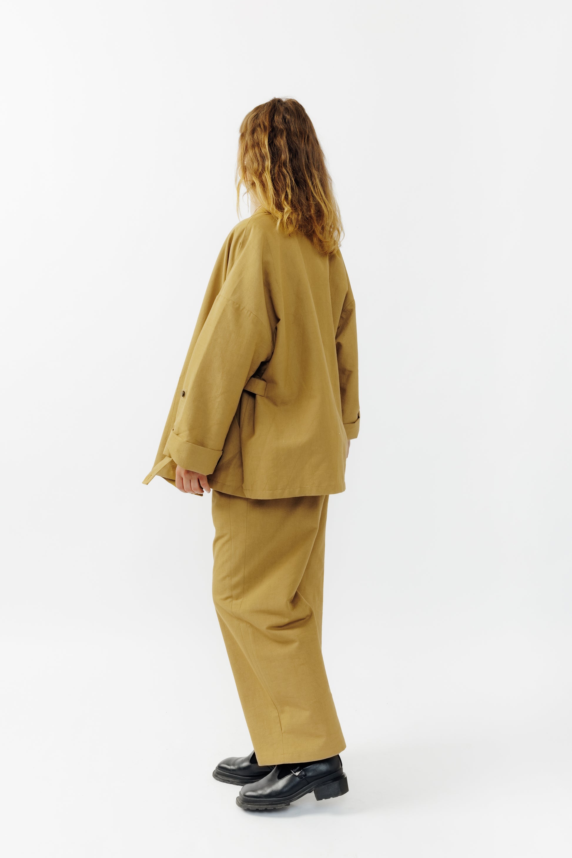 Veste croisée à col kimono de la marque Aïdama, modèle samue en crêpe de laine et coton sable. Portée ouverte par une mannequin femme et vu de dos.