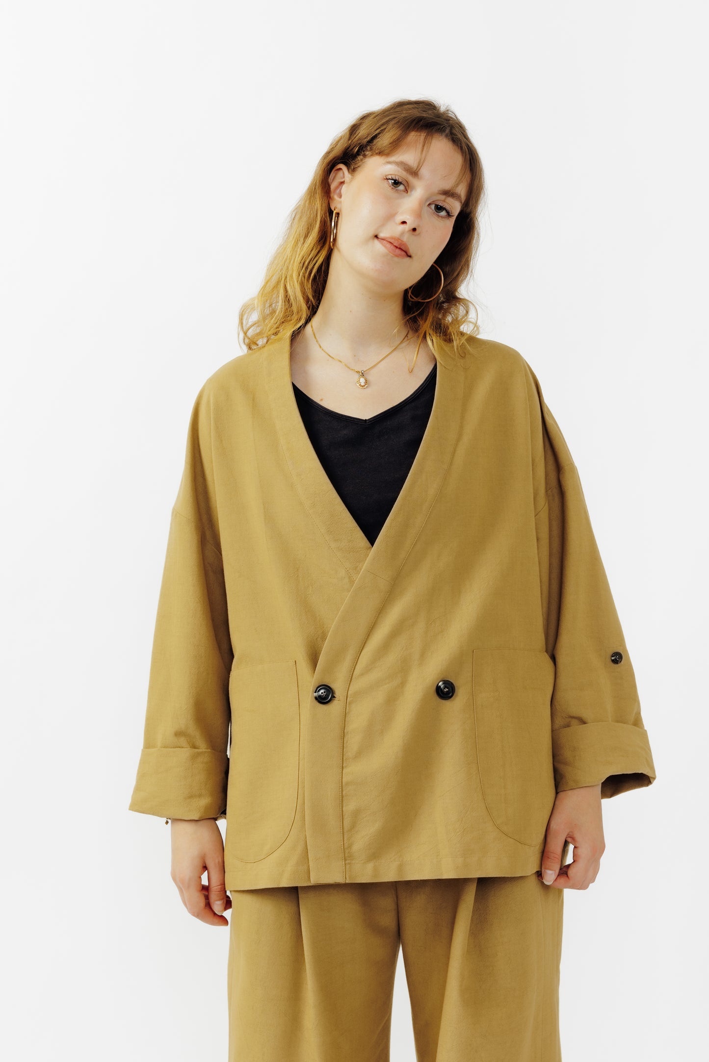 Veste croisée à col kimono de la marque Aïdama, modèle samue en crêpe de laine et coton sable. Portée fermée par une mannequin femme et vu de face. 
