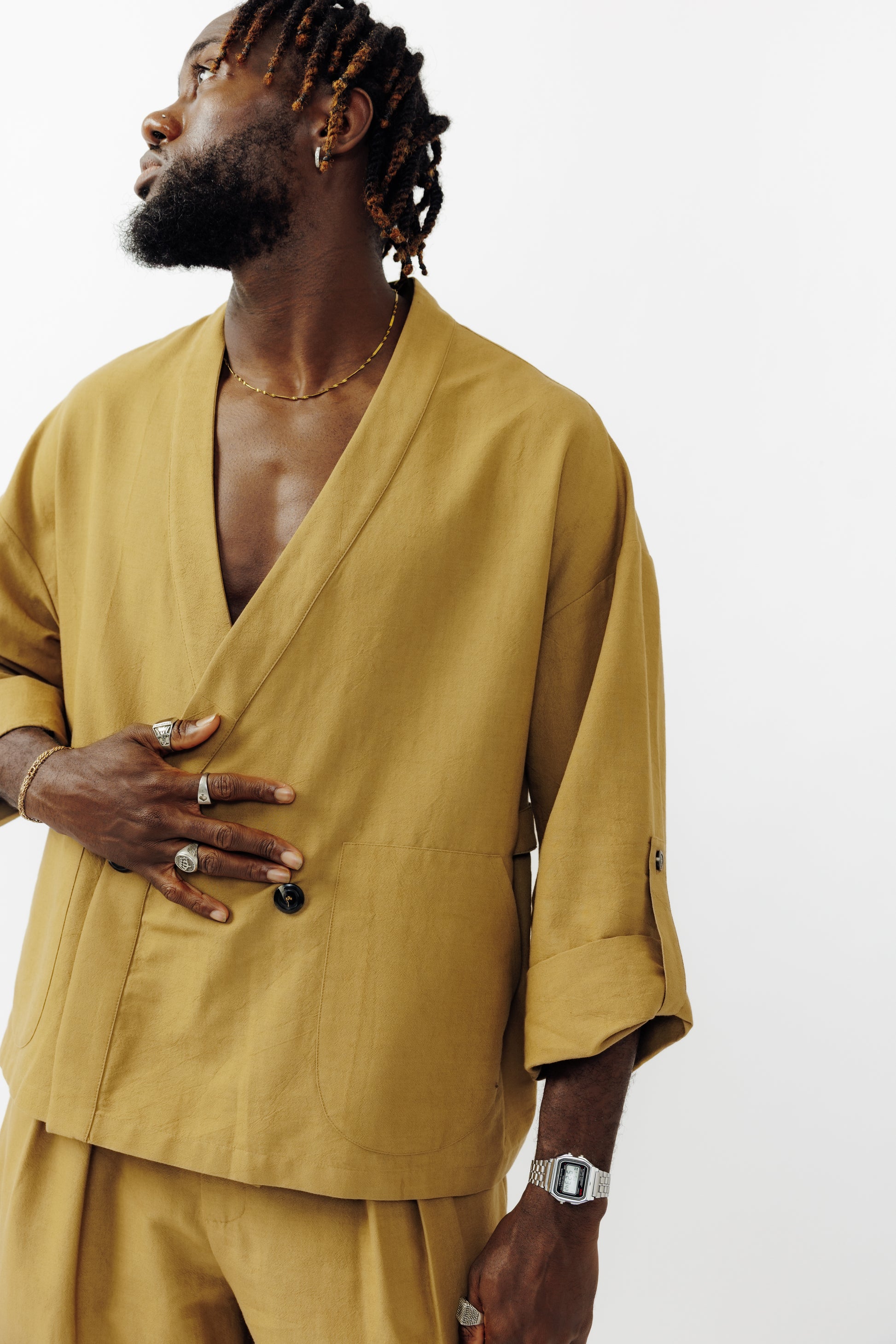 Veste croisée à col kimono de la marque Aïdama, modèle samue en crêpe de laine et coton sable. Portée fermée par un mannequin homme et vu de face. 