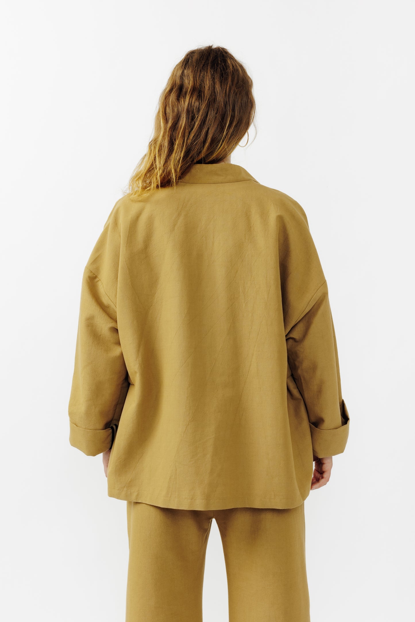 Veste croisée à col kimono de la marque Aïdama, modèle samue en crêpe de laine et coton sable. Portée fermée par une mannequin femme et vu de dos.