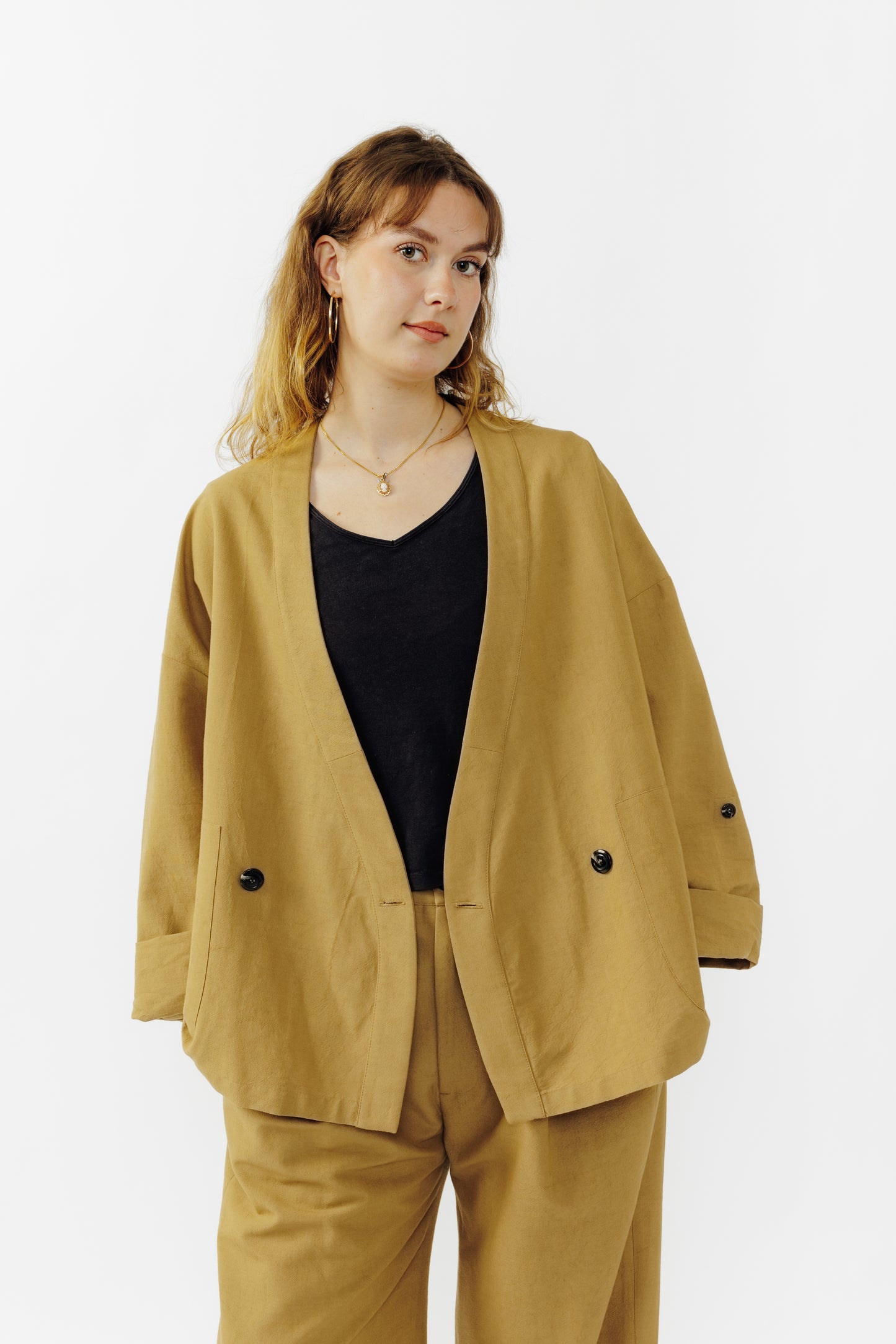 Veste croisée à col kimono de la marque Aïdama, modèle samue en crêpe de laine et coton sable. Portée ouverte par une mannequin femme et vu de face. 