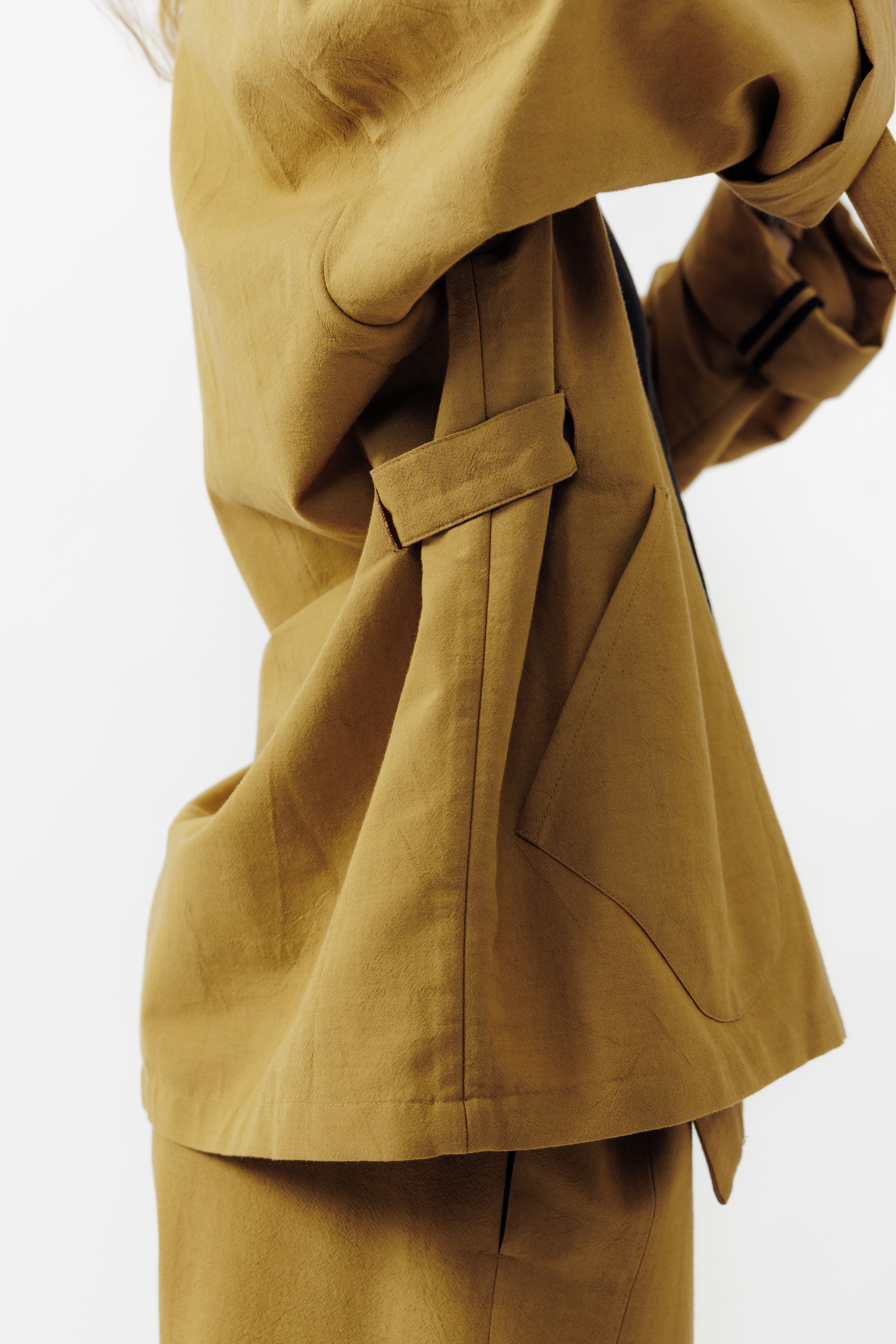 Veste croisée à col kimono de la marque Aïdama, modèle samue en crêpe de laine et coton sable. Portée ouverte par une mannequin femme et vu de profil