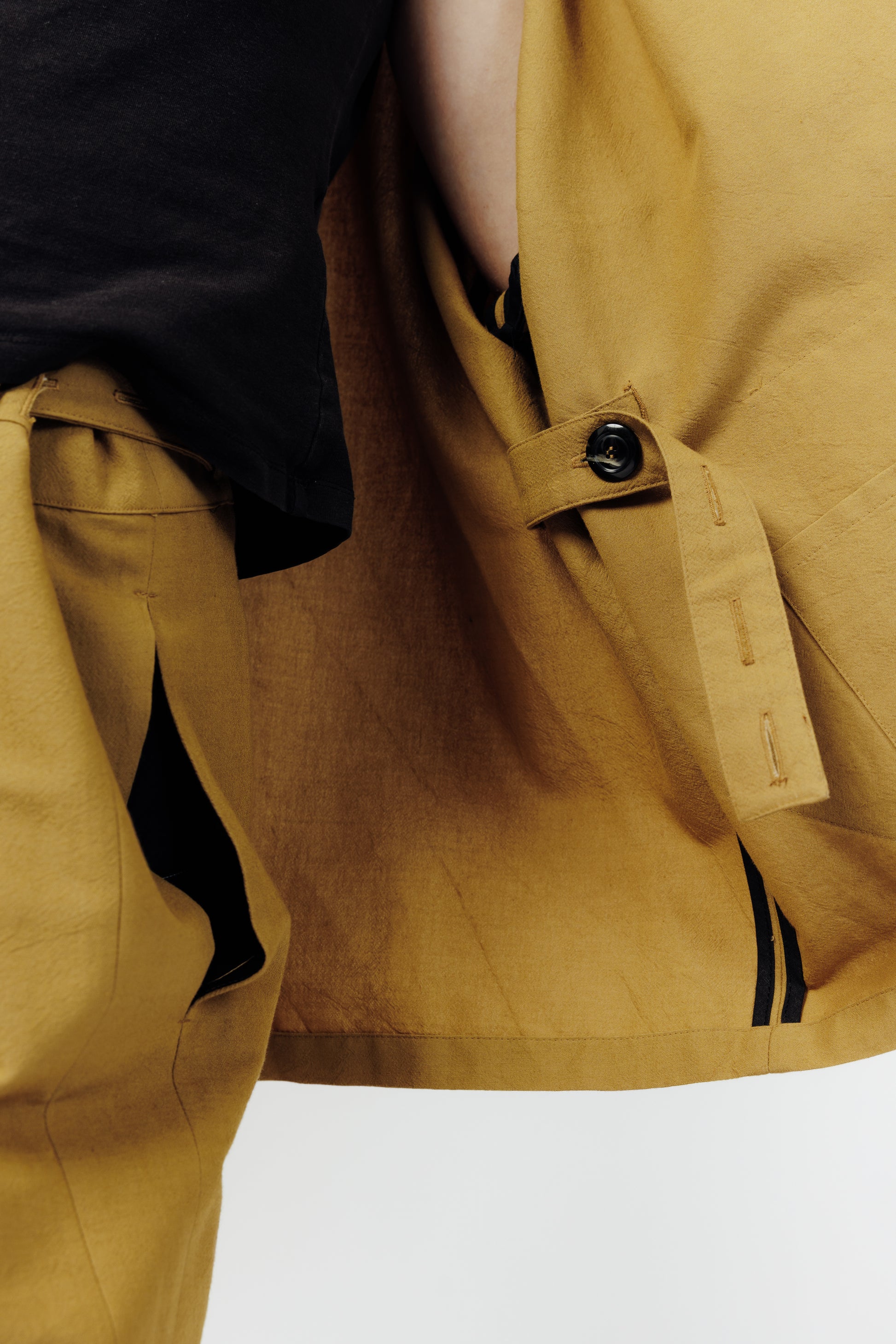 Veste croisée à col kimono de la marque Aïdama, modèle samue en crêpe de laine et coton sable. Portée ouverte par une mannequin femme et vue zoomée sur la sangle de réglage.
