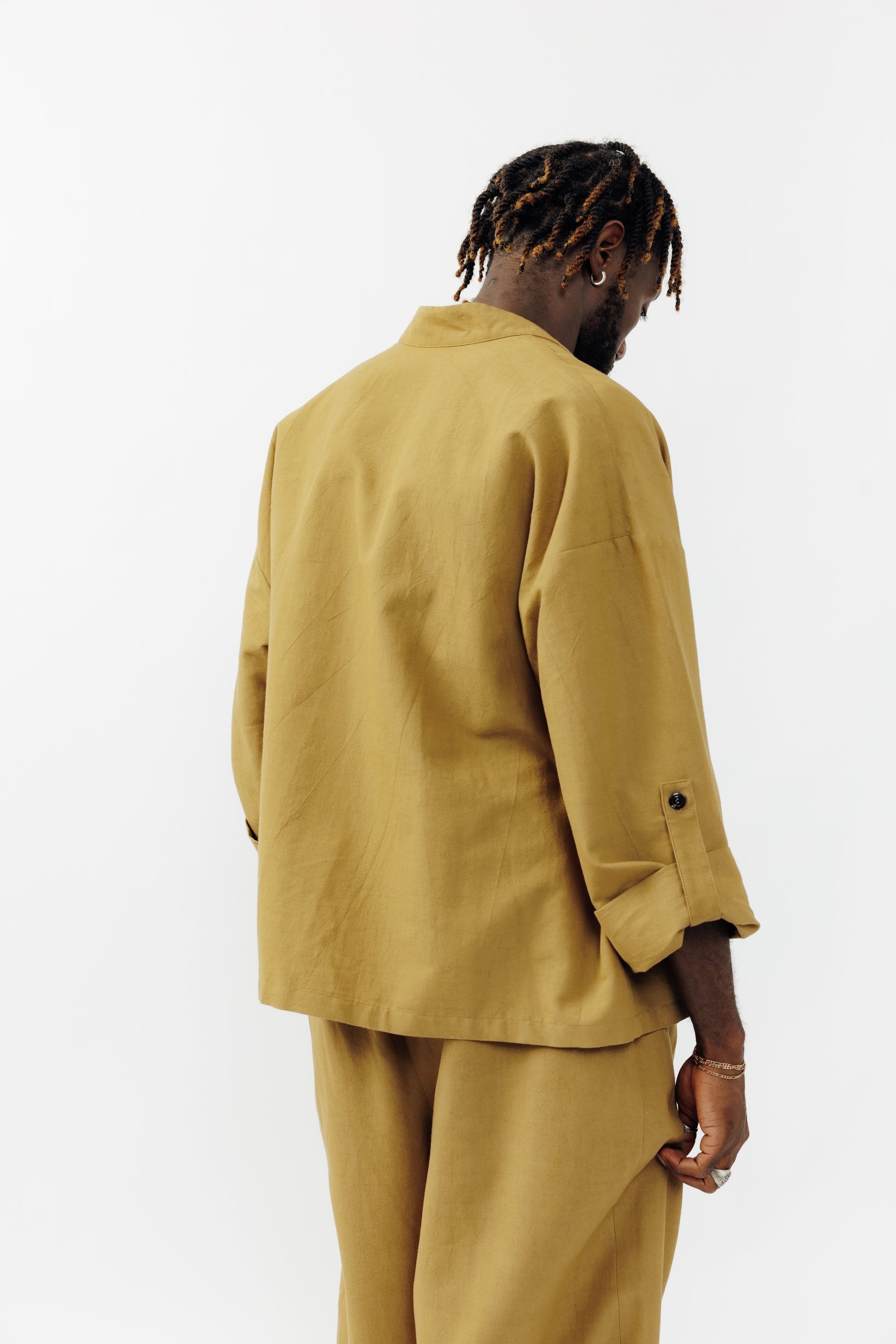 Veste croisée à col kimono de la marque Aïdama, modèle samue en crêpe de laine et coton sable. Portée ouverte par un mannequin homme et vu de dos.