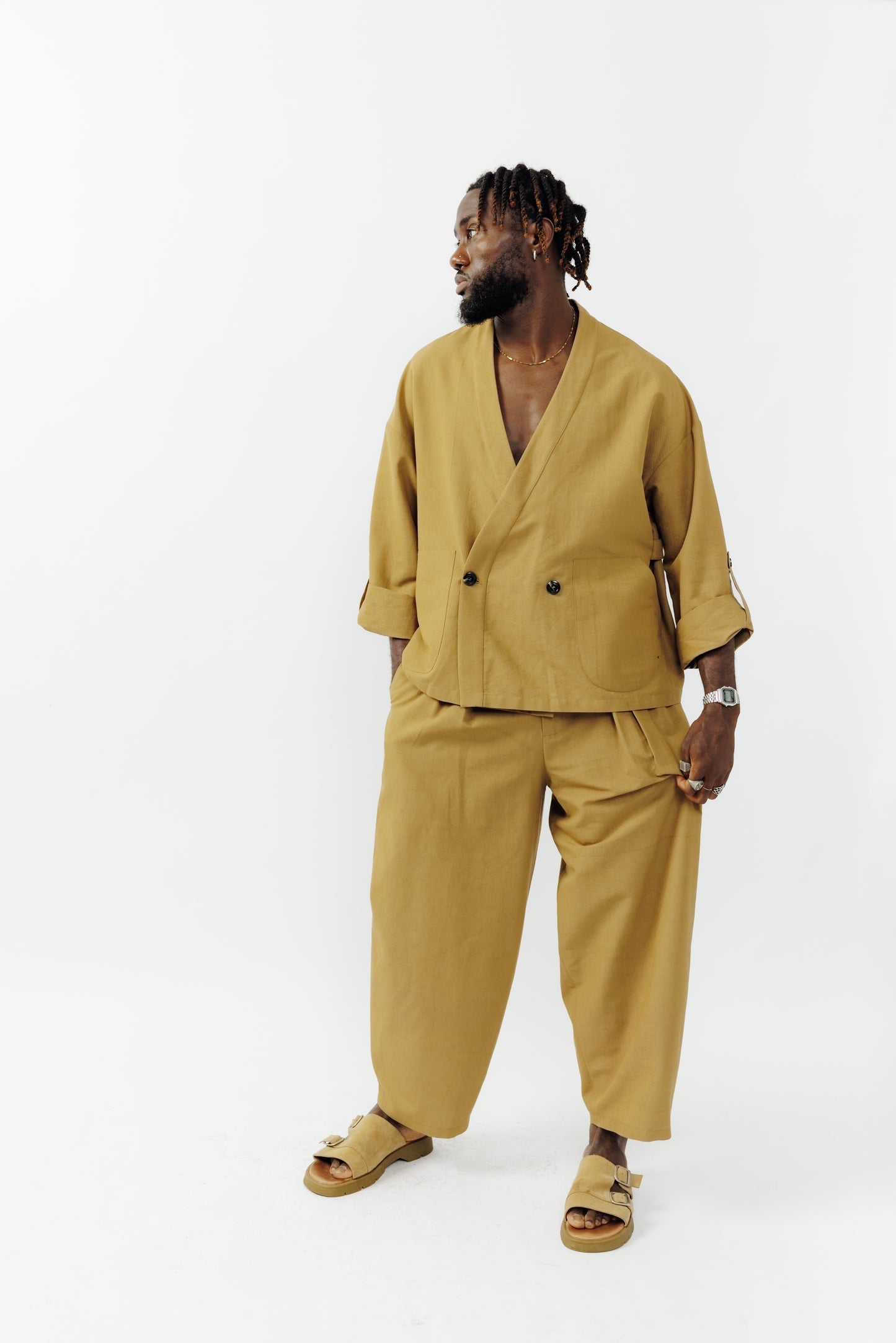 Veste croisée à col kimono de la marque Aïdama, modèle samue en crêpe de laine et coton sable. Portée fermée par un mannequin homme et vu de face. 