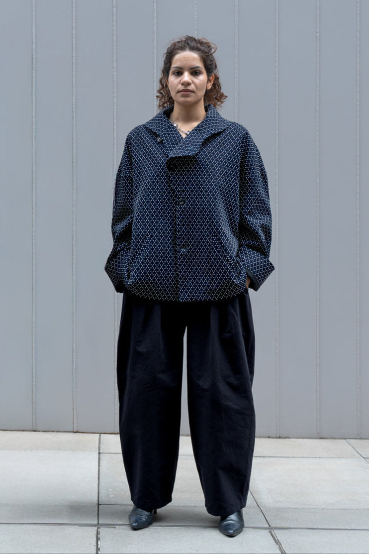 Veste oversize à col arrondi de la marque Aïdama, modèle Gunbai en coton japonais bleu brodé de points Sashiko. Portée fermée par une mannequin femme et vue de face. 
