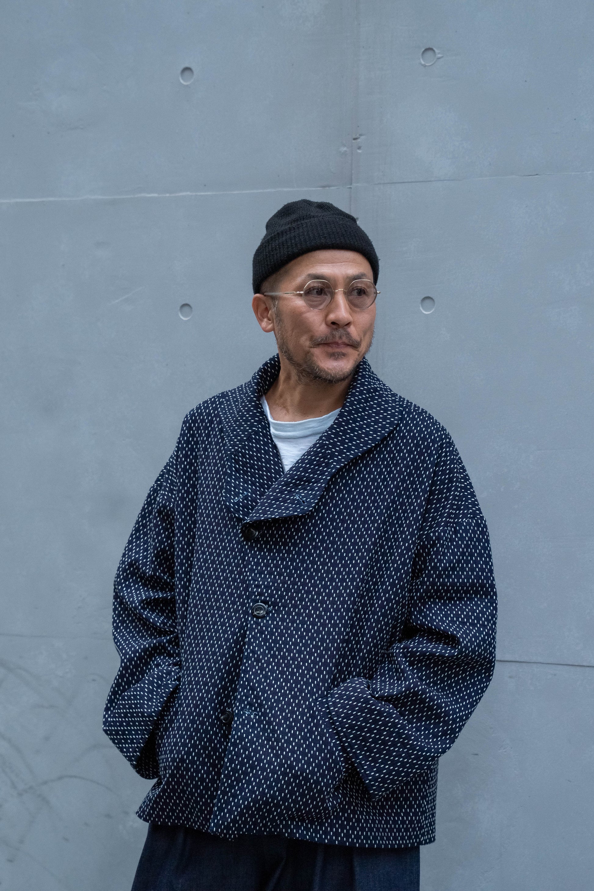 Veste oversize à col arrondi de la marque Aïdama, modèle Gunbai en coton japonais bleu brodé de points Sashiko. Portée par un mannequin homme et vue de face. 