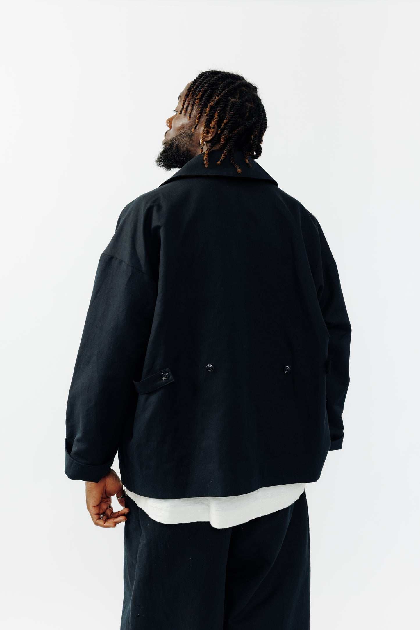 Veste oversize à col arrondi de la marque Aïdama, modèle Gunbai en coton & lin noir. Portée fermée par un mannequin homme et vue de dos.