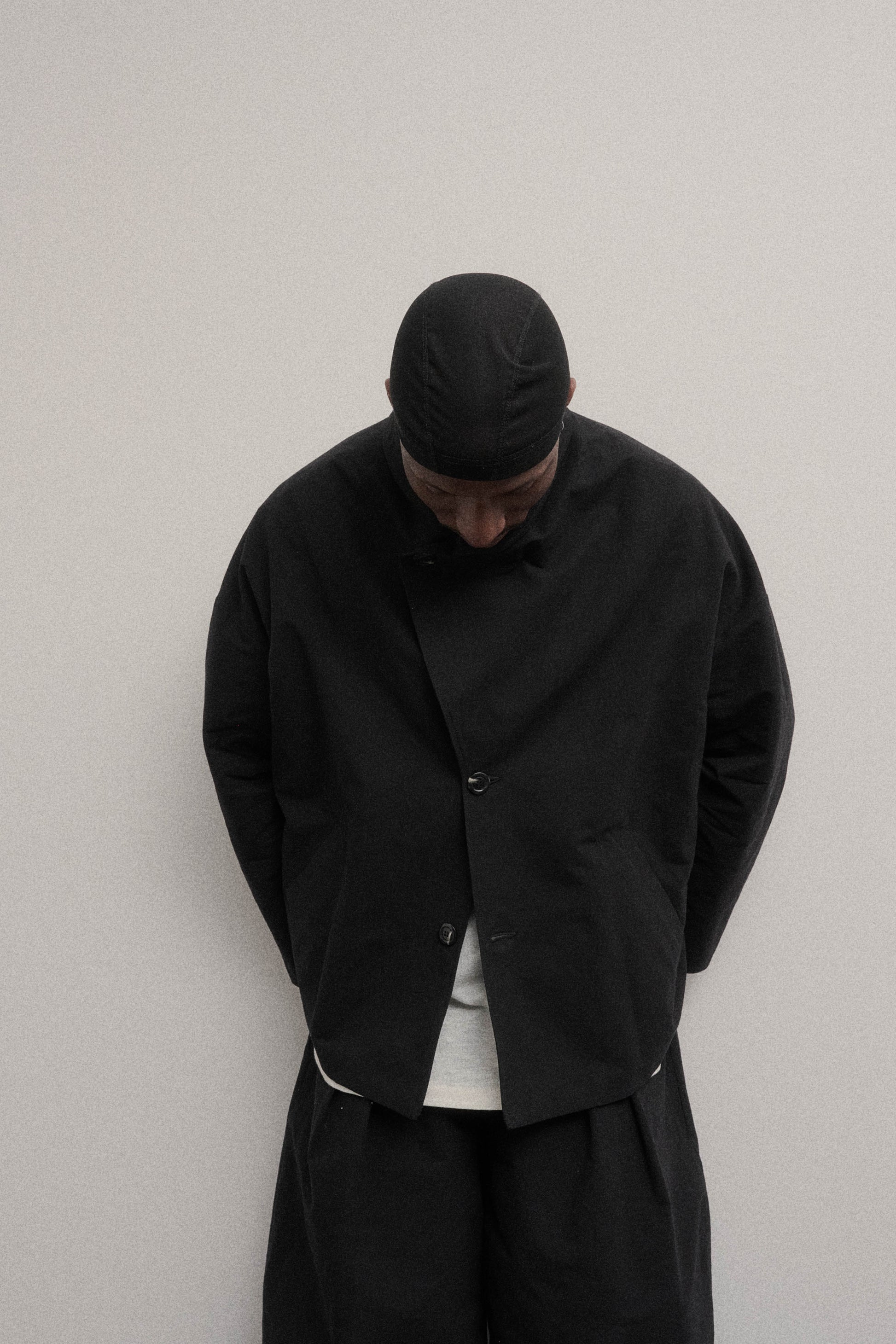 Veste oversize à col arrondi de la marque Aïdama en mélange de coton et papier japonais noir. Portée fermée par un mannequin homme et vu de face.