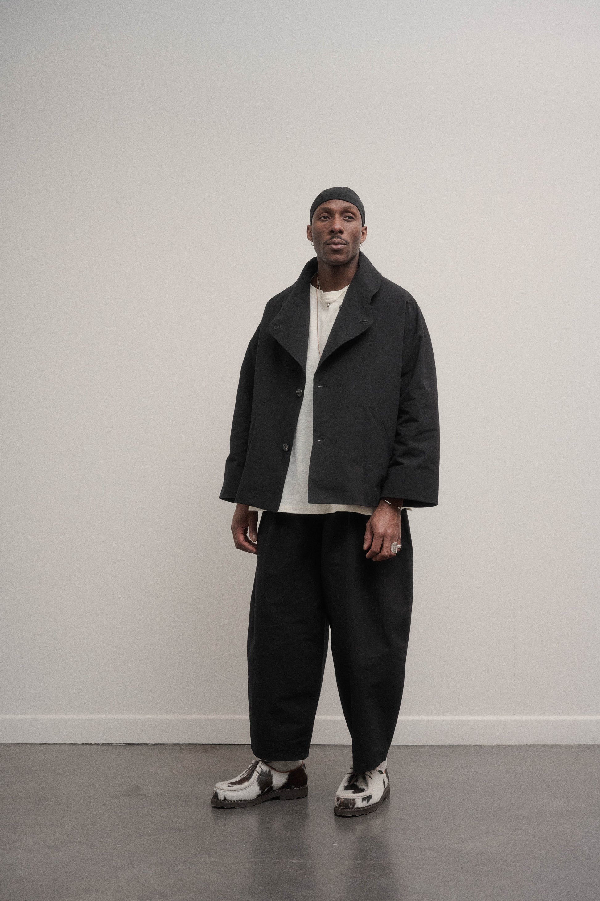 Veste oversize à col arrondi de la marque Aïdama en mélange de coton et papier japonais noir. Portée ouverte par un mannequin homme et vu de face.