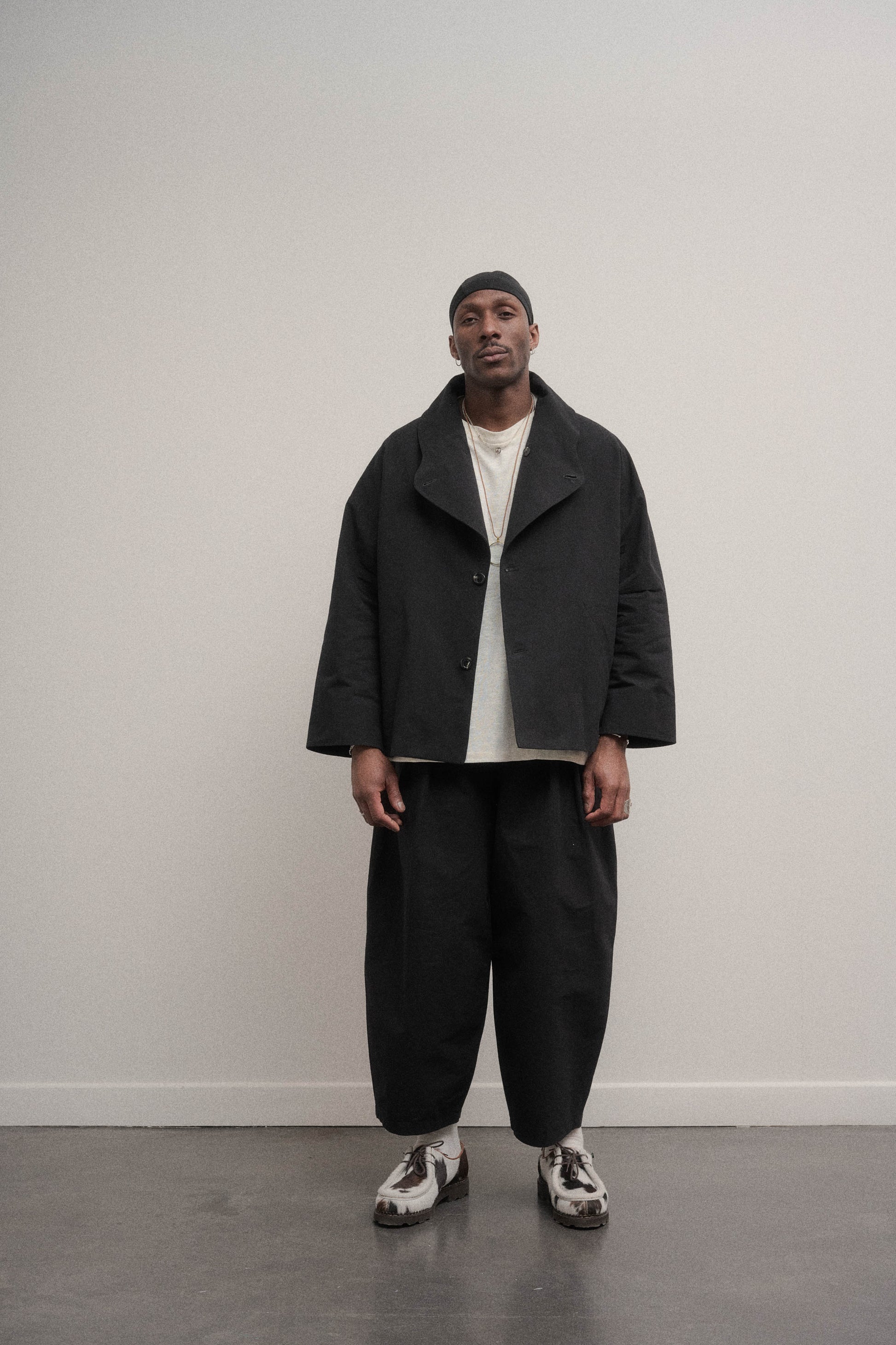 Veste oversize à col arrondi de la marque Aïdama en mélange de coton et papier japonais noir. Portée ouverte par un mannequin homme et vu de face. 