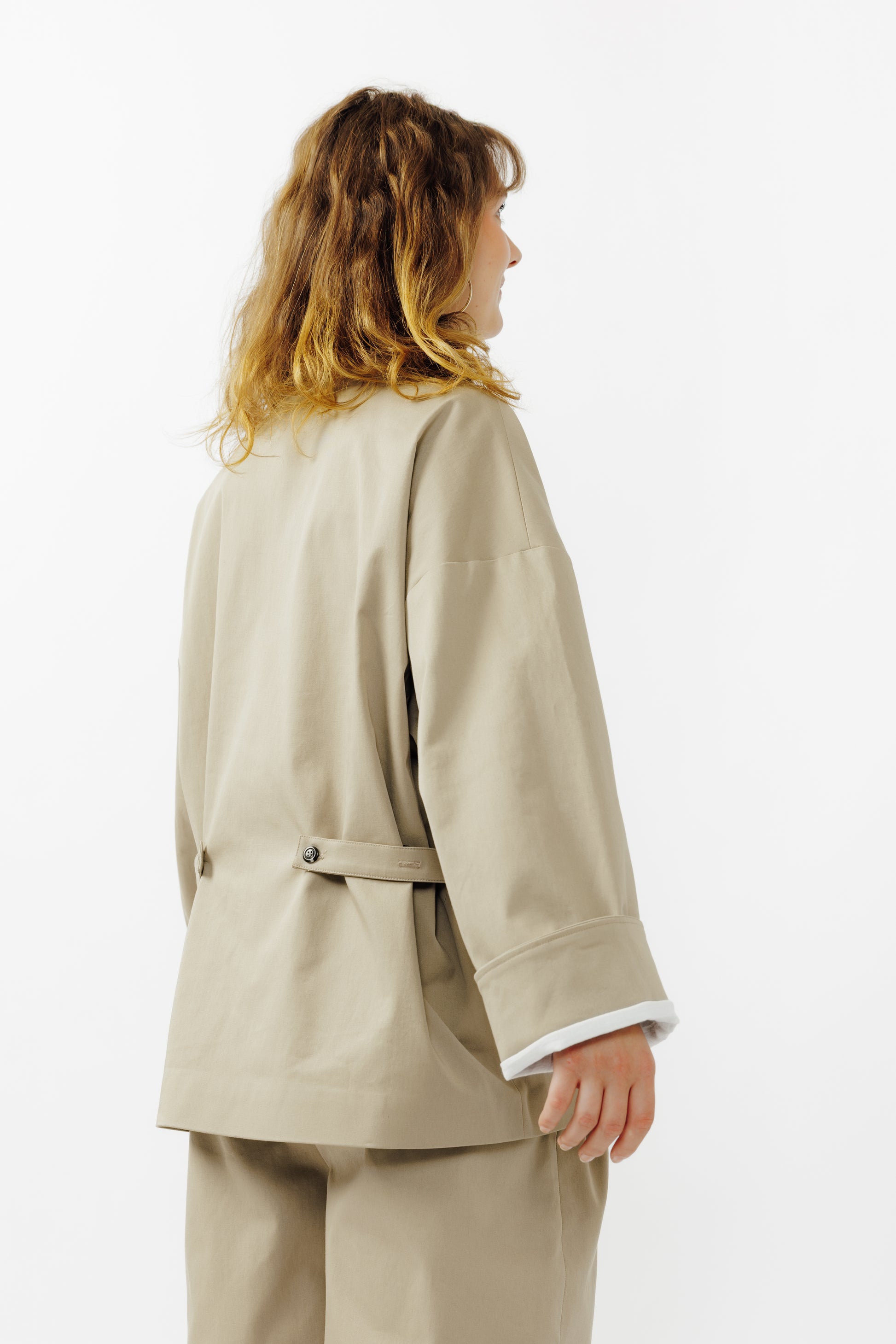 Veste oversize à col arrondi de la marque Aïdama, modèle Gunbai en gabardine de coton beige. Portée fermée par une mannequin femme et vue de dos.