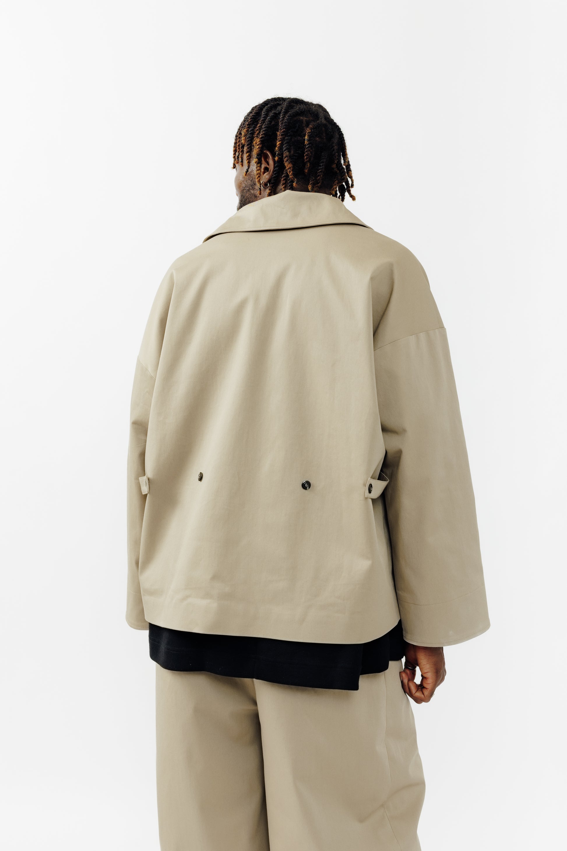 Veste oversize à col arrondi de la marque Aïdama, modèle Gunbai en gabardine de coton beige. Portée fermée par un mannequin homme et vue de dos.