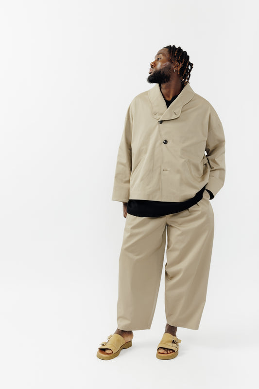 Veste oversize à col arrondi de la marque Aïdama, modèle Gunbai en gabardine de coton beige. Portée fermée par un mannequin homme et vue de face.