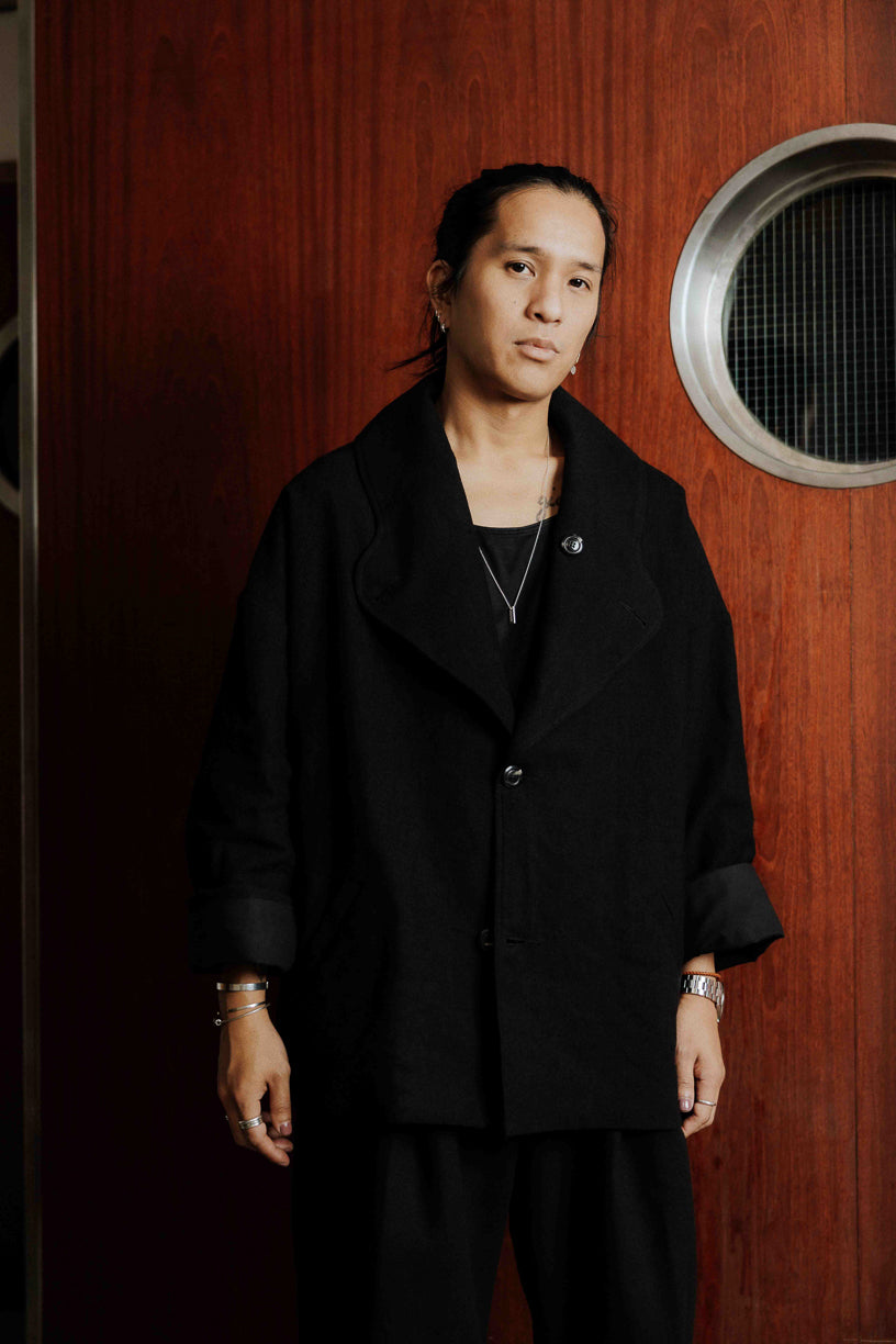 Veste oversize à col arrondi de la marque Aïdama, modèle Gunbai en laine et lin noir Portée fermée par un mannequin homme et vue de face.
