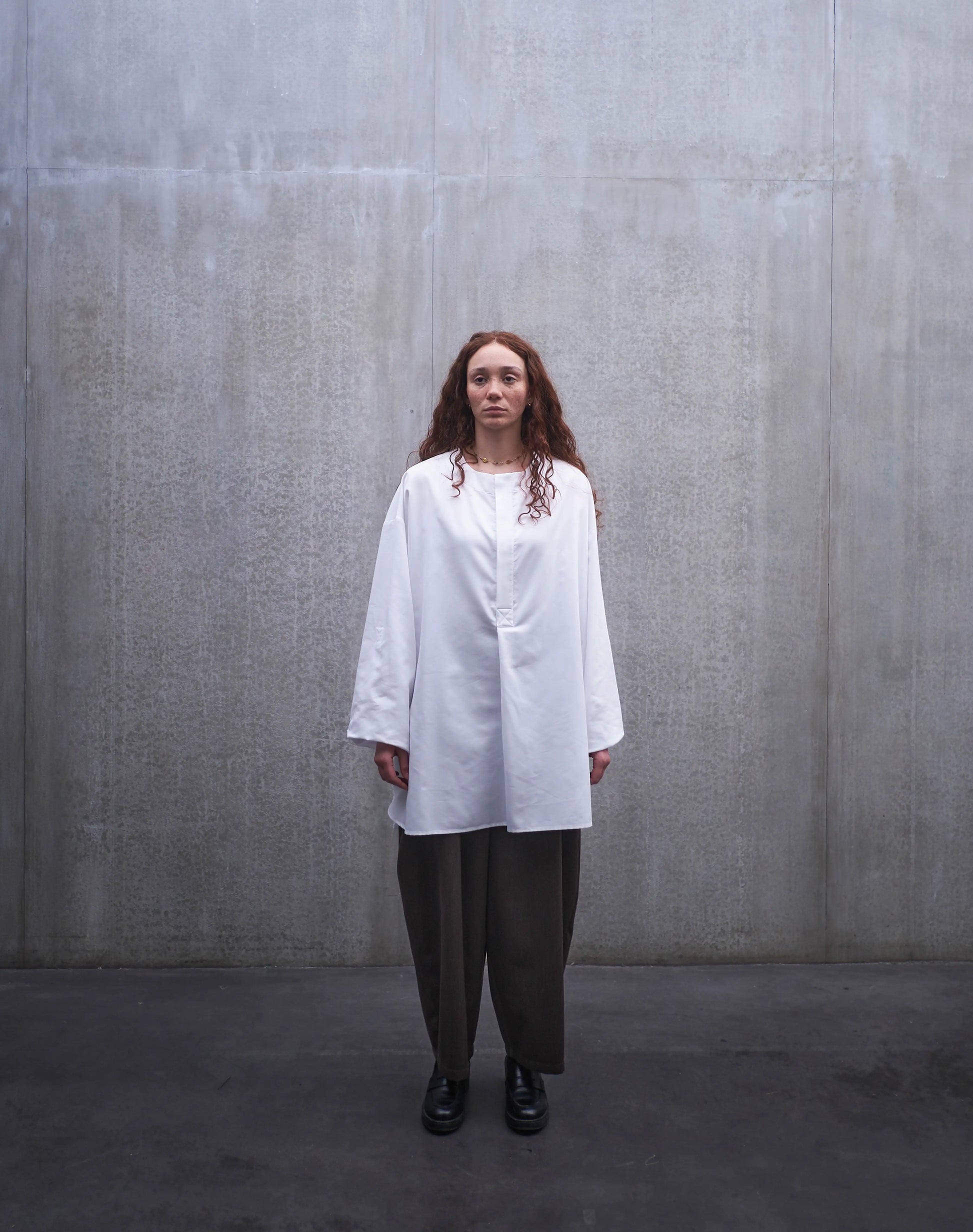 Chemise à manche longue et col rond Aïdama modèle Ao en popeline de coton blanc. Portée par une mannequin femme et vue de face.