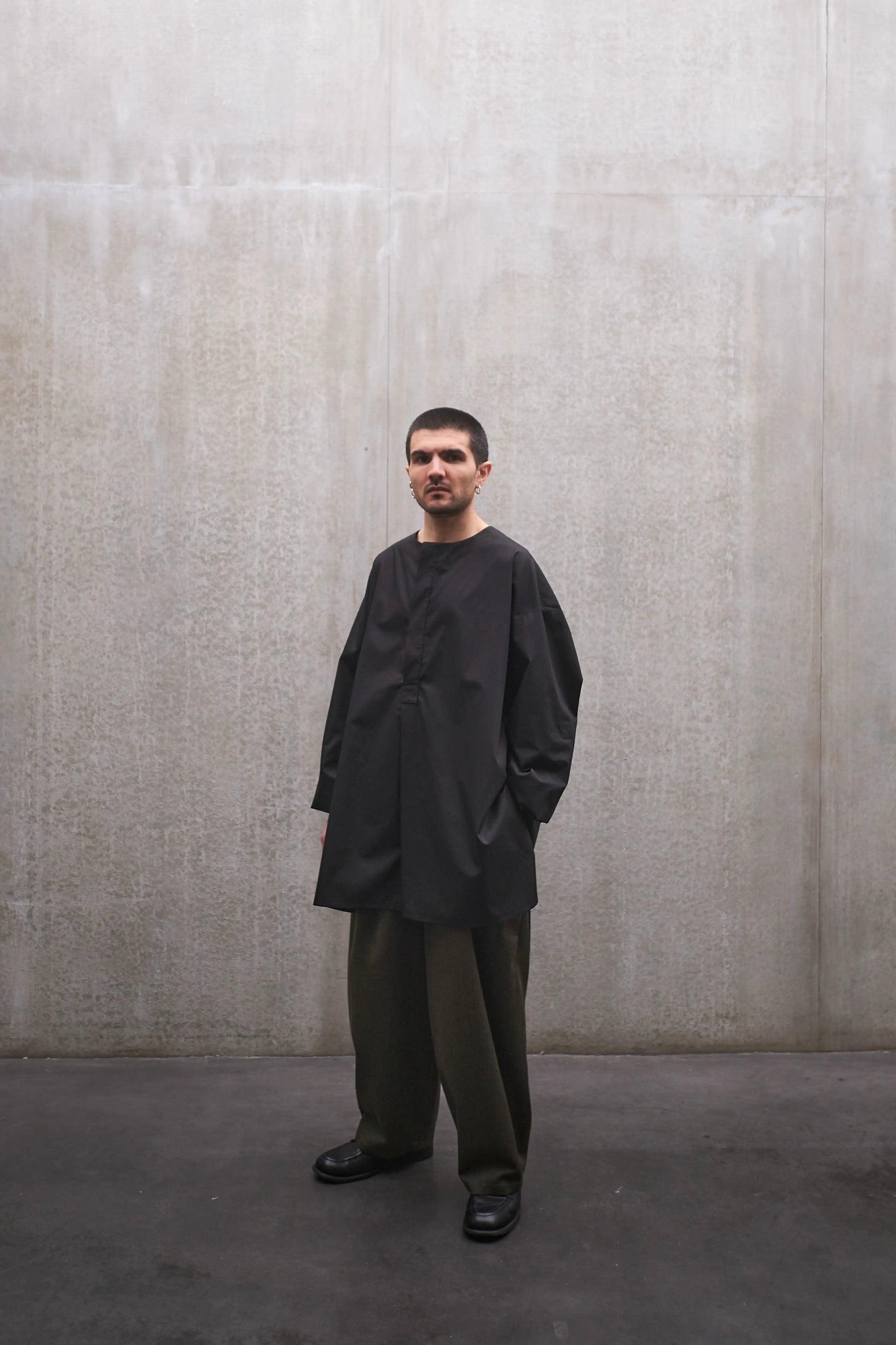 Chemise à manche longue et col rond Aïdama modèle Ao en popeline de coton noir. Portée par un mannequin homme et vue de face.