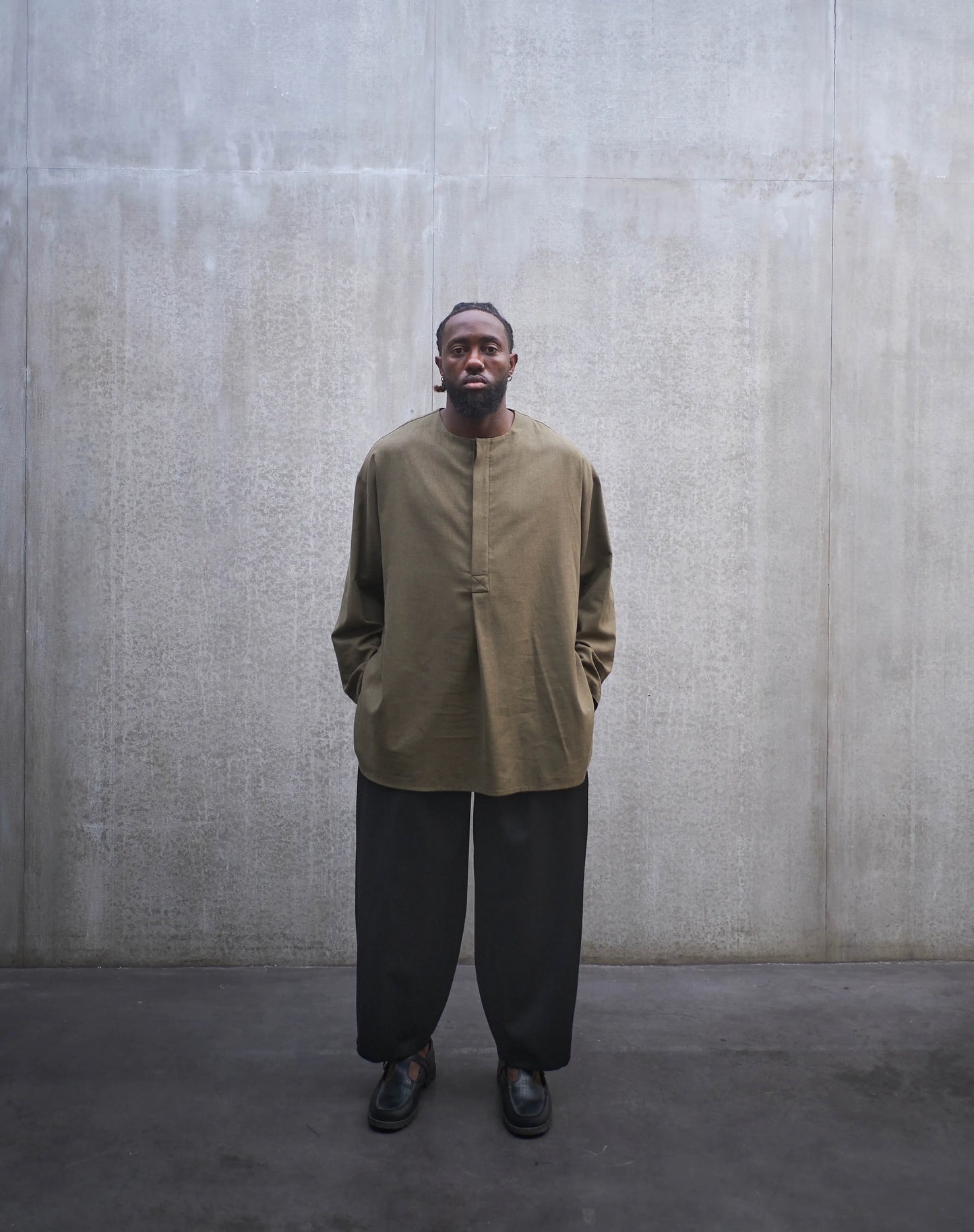 Chemise oversize à manche longue et col rond Aïdama modèle Ao en coton vert chiné. Portée par un mannequin homme et vue de face.