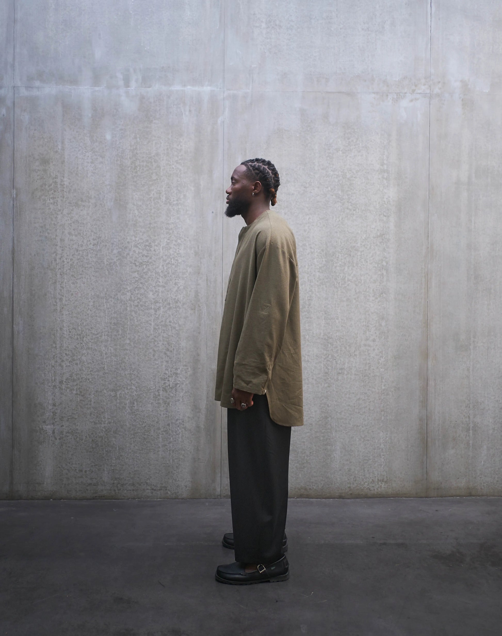 Chemise oversize à manche longue et col rond Aïdama modèle Ao en coton vert chiné. Portée par un mannequin homme et vue de profil.