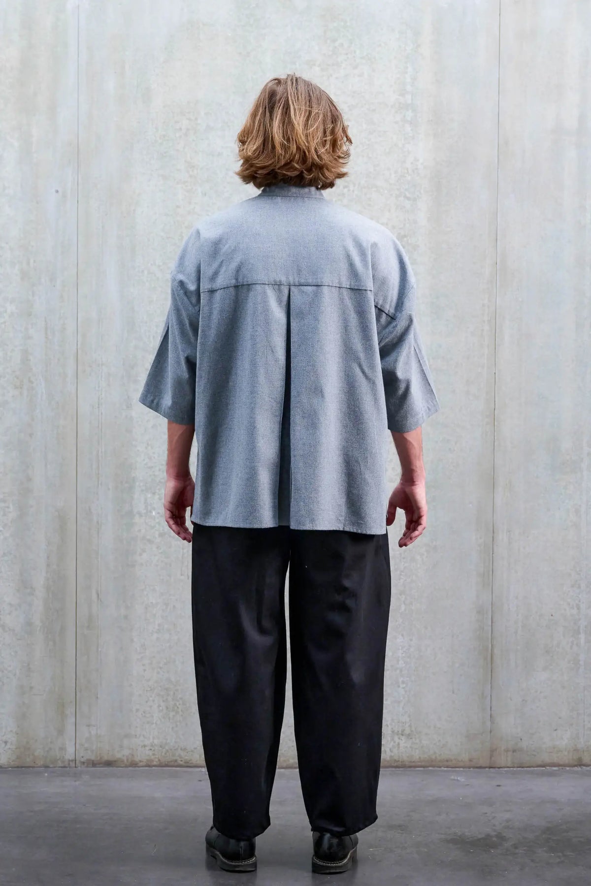 Chemise boxy à col officier Aïdama, modèle Kita en coton brossé gris clair. Portée par un mannequin homme et vue de dos.