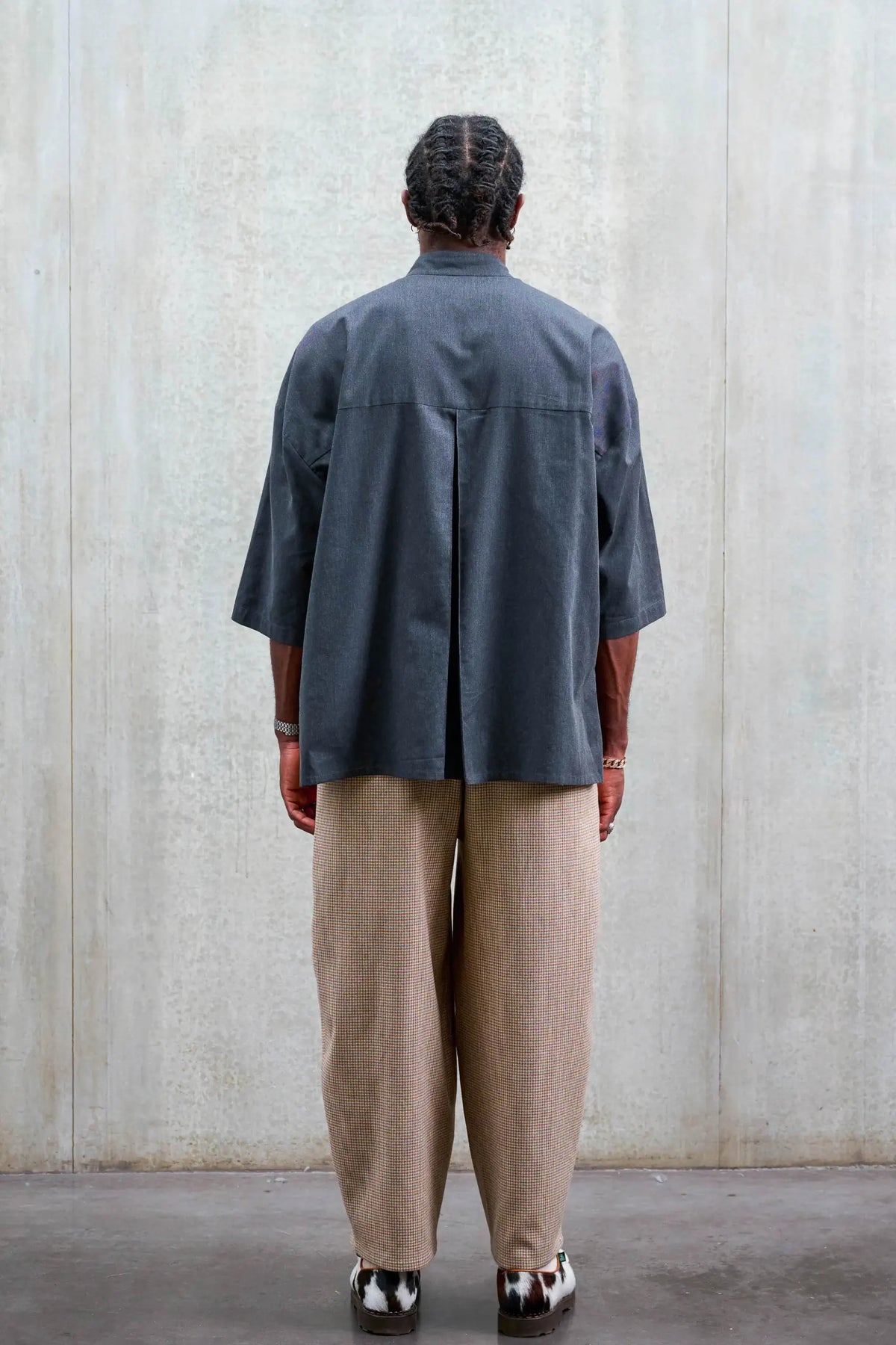 Chemise boxy à col officier de la marque Aïdama, modèle Kita en coton gris foncé. Portée par un mannequin homme et vue de dos.