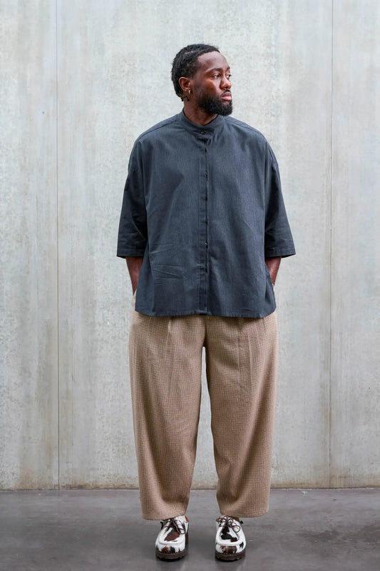 Chemise boxy à col officier de la marque Aïdama, modèle Kita en coton gris foncé. Portée par un mannequin homme et vue de face.