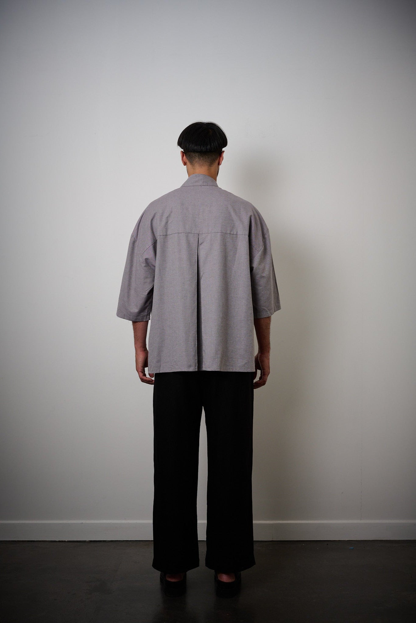 Chemise oversize à manches courtes et col officier de la marque Aïdama, modèle Kita en coton lavande-gris. Portée par un mannequin homme et vue de dos