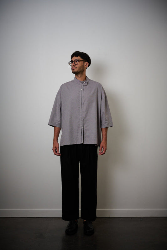 Chemise oversize à manches courtes et col officier de la marque Aïdama, modèle Kita en coton lavande-gris. Portée par un mannequin homme et vue de face.