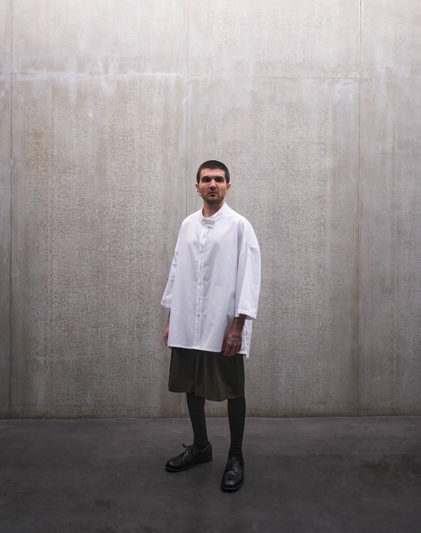 Chemise boxy à manches courtes et col officier Aïdama modèle Kita en popeline de coton blanc. Portée par un mannequin homme et vue de face.