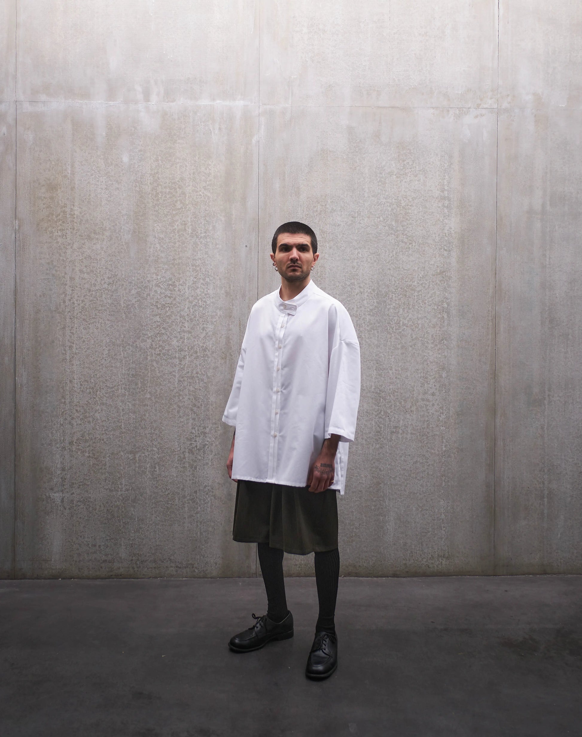 Chemise boxy à manches courtes et col officier Aïdama modèle Kita en popeline de coton blanc. Portée par un mannequin homme et vue de face.