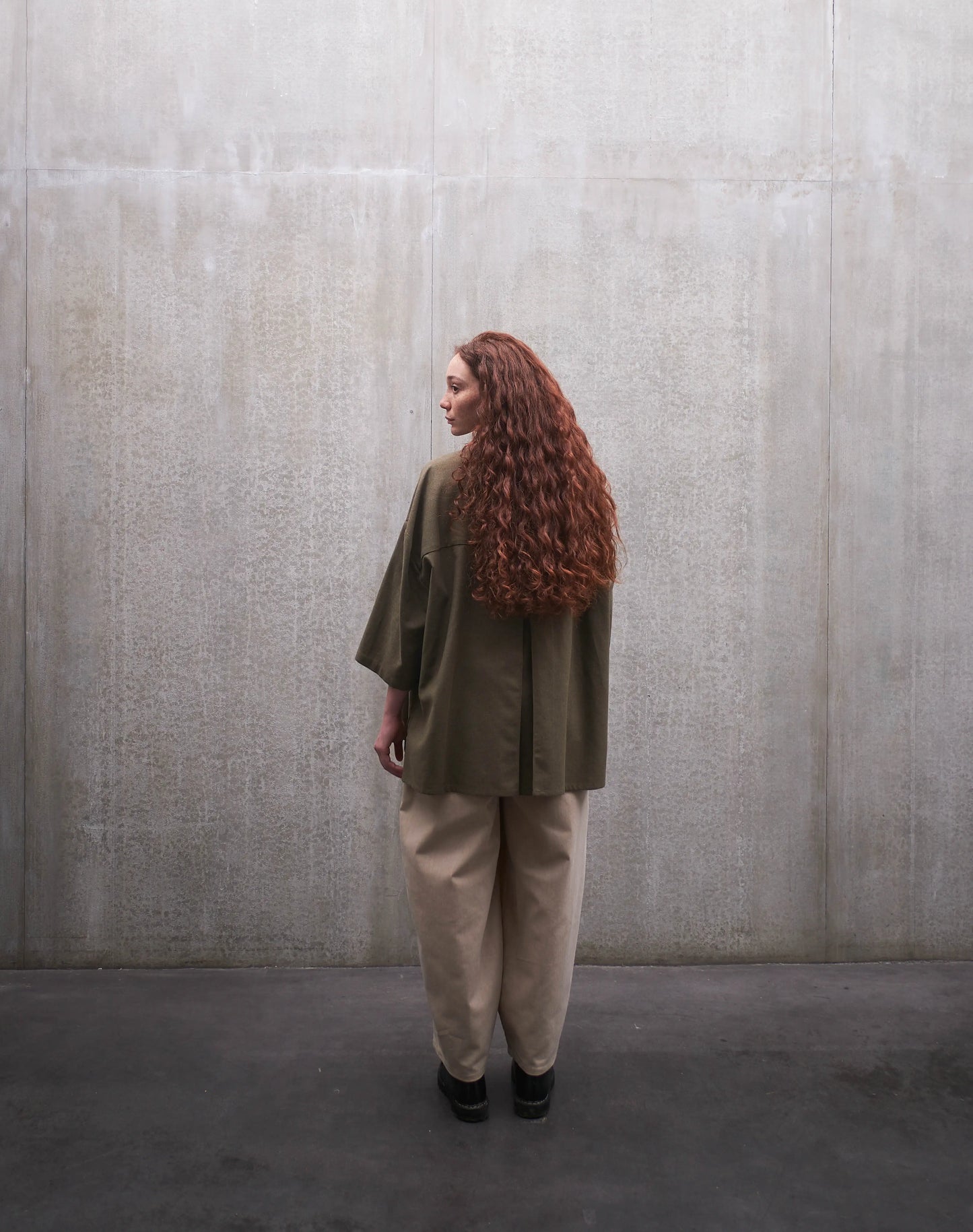 Chemise boxy à manches courtes et col officier Aïdama modèle Kita en coton vert chiné. Portée par une mannequin femme et vue de dos.