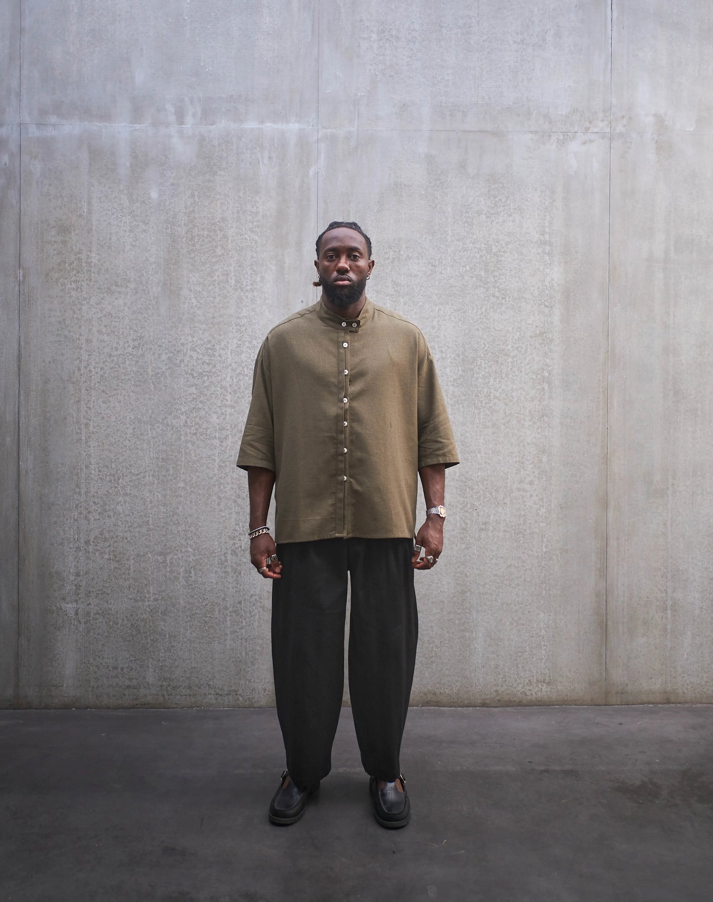 Chemise boxy à manches courtes et col officier Aïdama modèle Kita en coton vert chiné. Portée par un mannequin homme et vue de face.