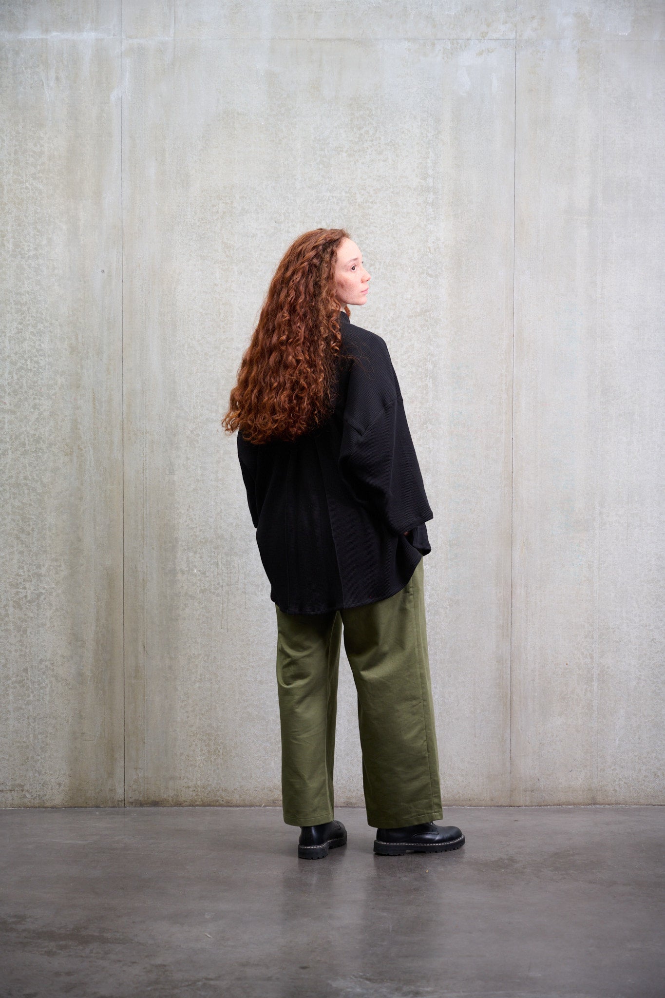 Chemise oversize à col officier, coupe boxy en coton nid d'abeille noir. Portée fermée par une mannequin femme et vue de dos.