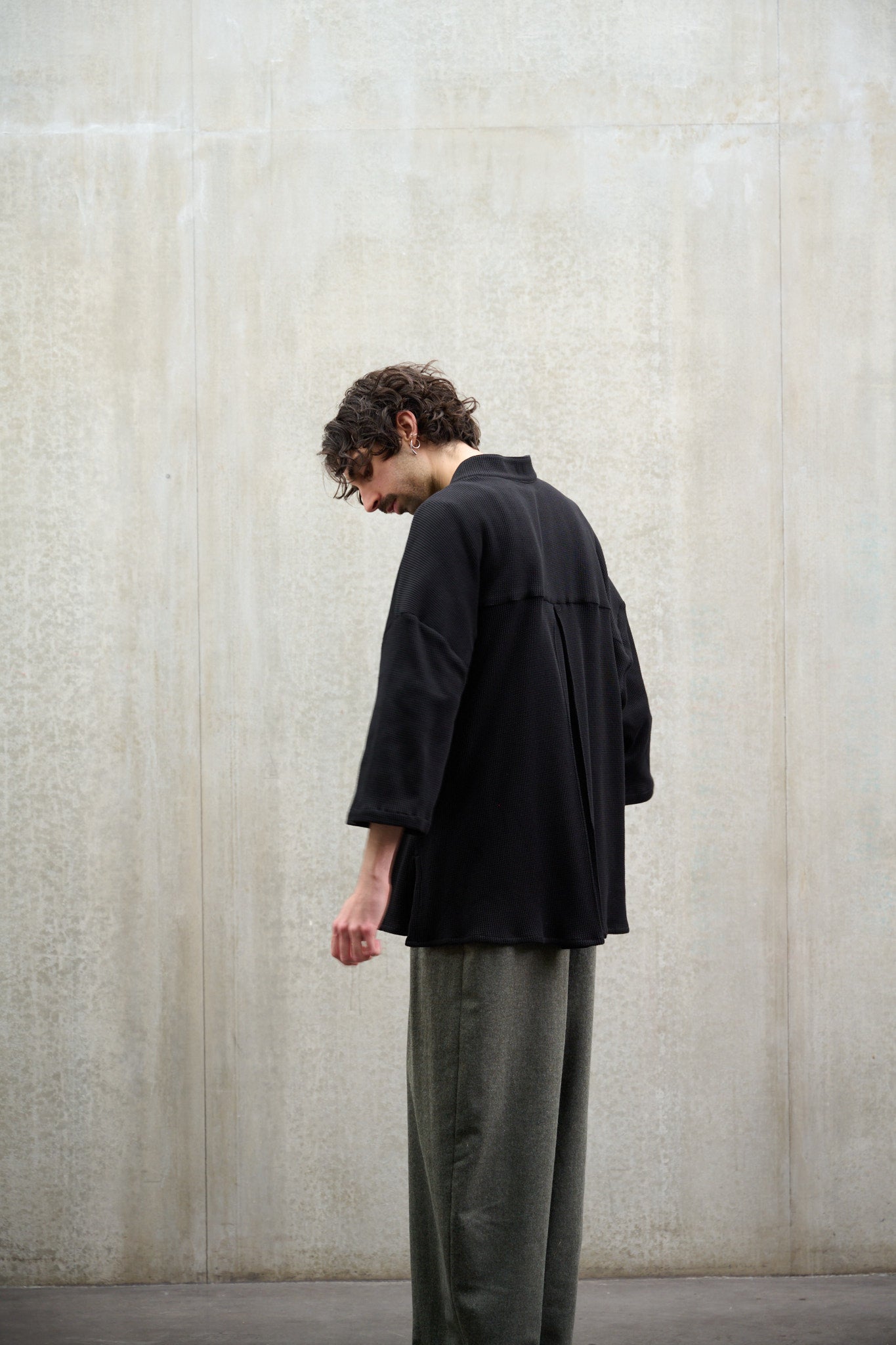 Chemise oversize à col officier, coupe boxy en coton nid d'abeille noir. Portée fermée par un mannequin homme et vue de dos.