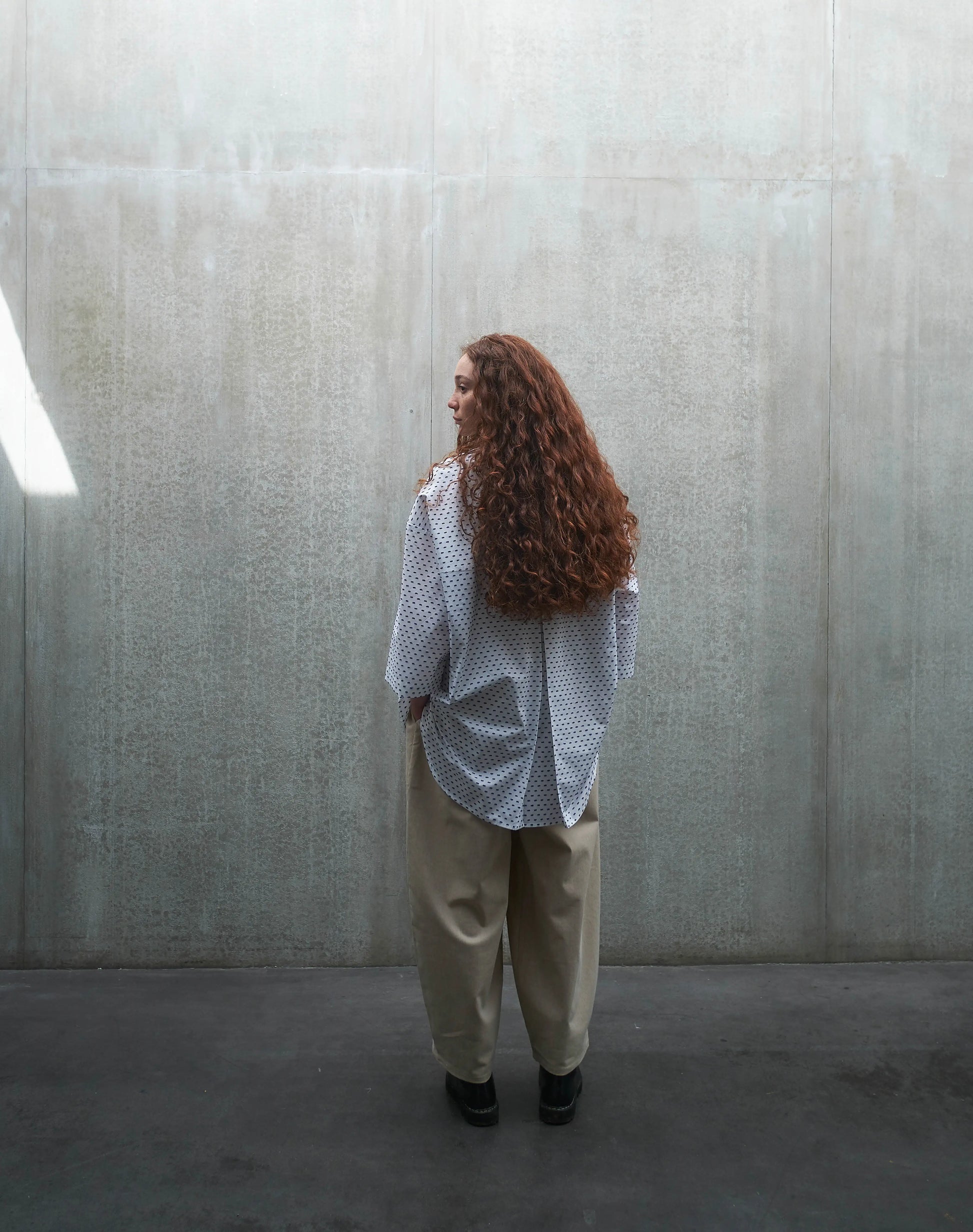 Chemise oversize à manches courtes et col club Aïdama modèle Marui en coton blanc à pois bleus. Portée par une mannequin femme et vue de dos.