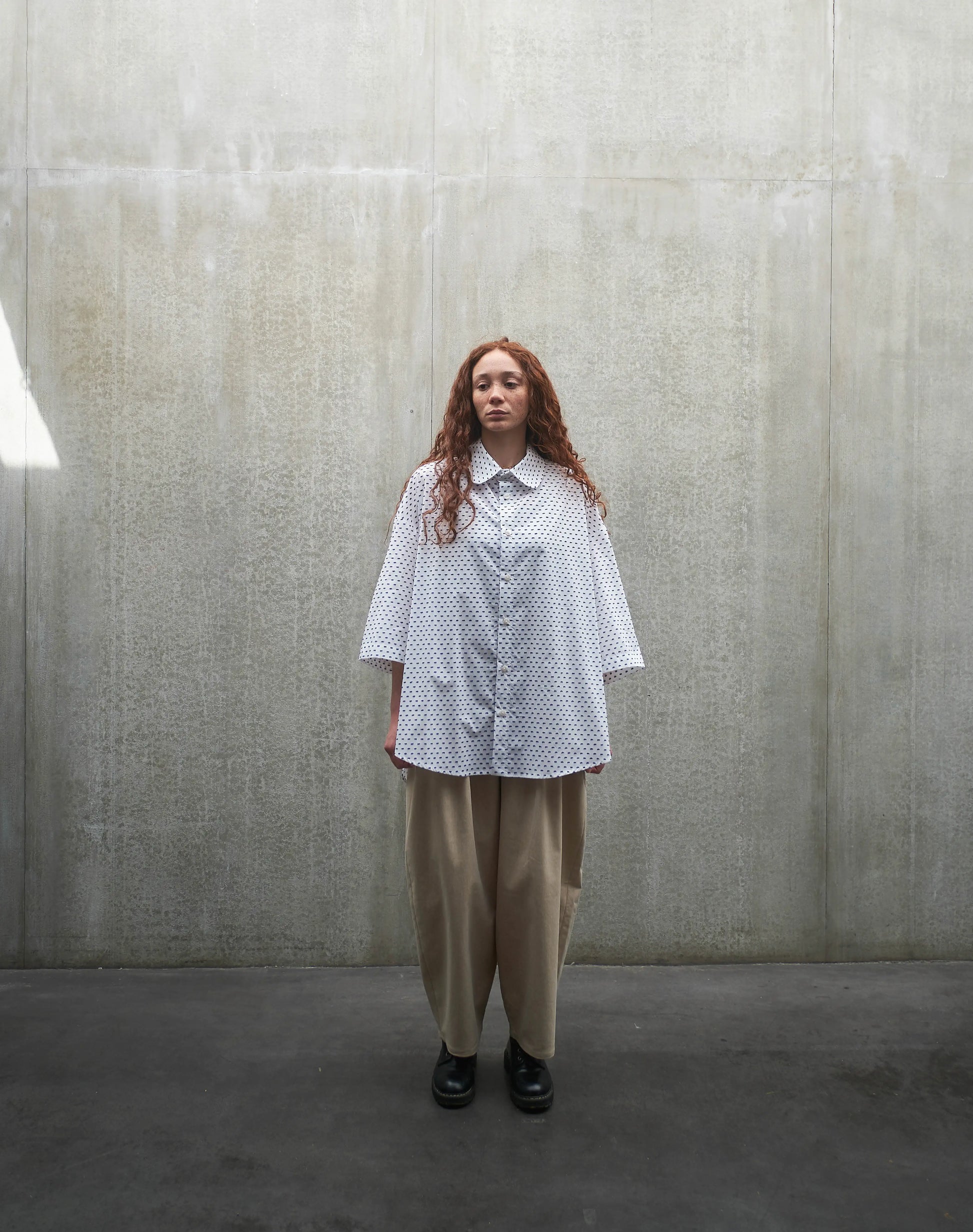 Chemise oversize à manches courtes et col club Aïdama modèle Marui en coton blanc à pois bleus. Portée par une mannequin femme et vue de face.