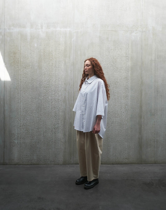 Chemise oversize à manches courtes et col club Aïdama modèle Marui en coton blanc à pois bleus. Portée par une mannequin femme et vue de profil.