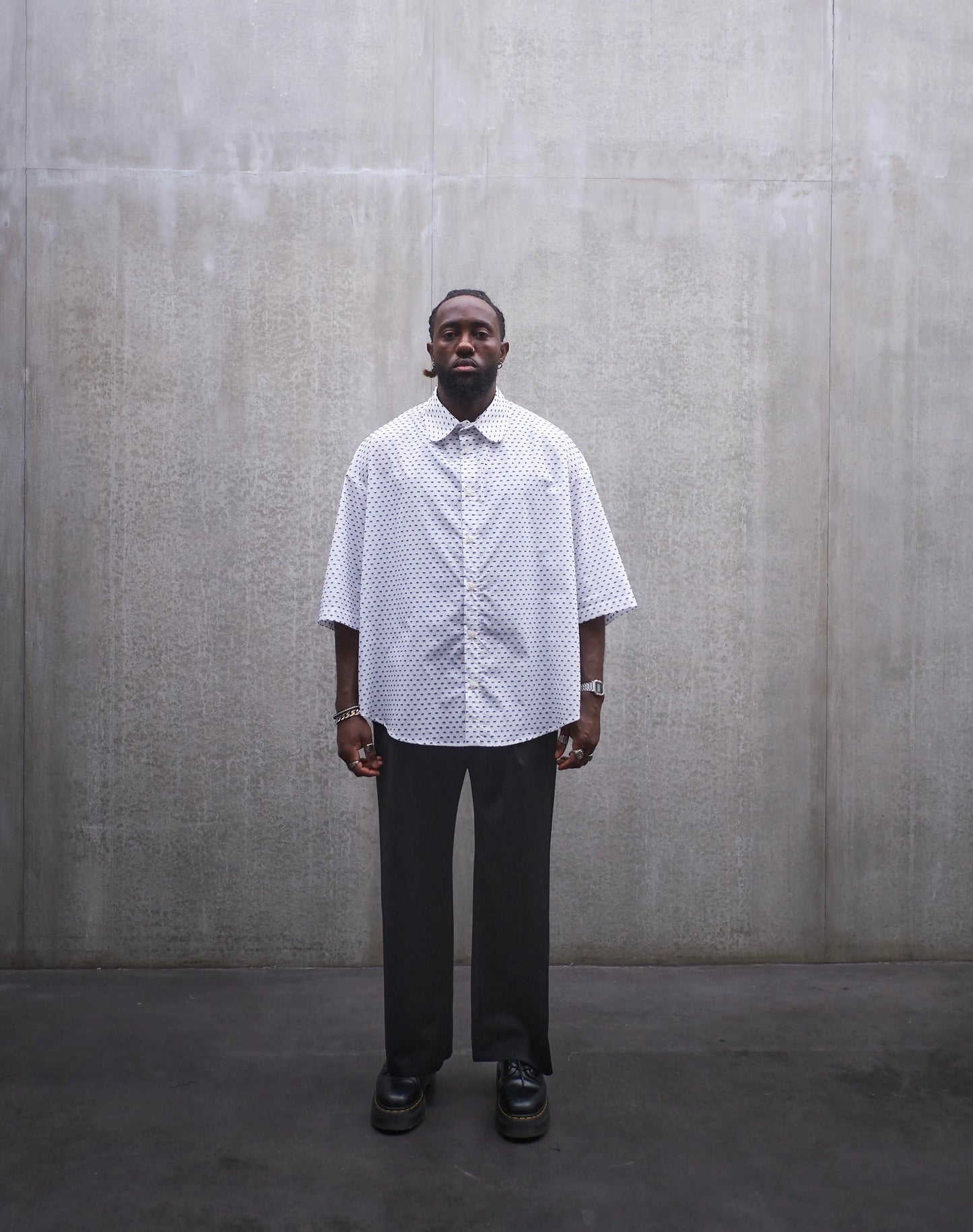Chemise oversize à manches courtes et col club Aïdama modèle Marui en coton blanc à pois bleus. Portée par un mannequin homme et vue de face.
