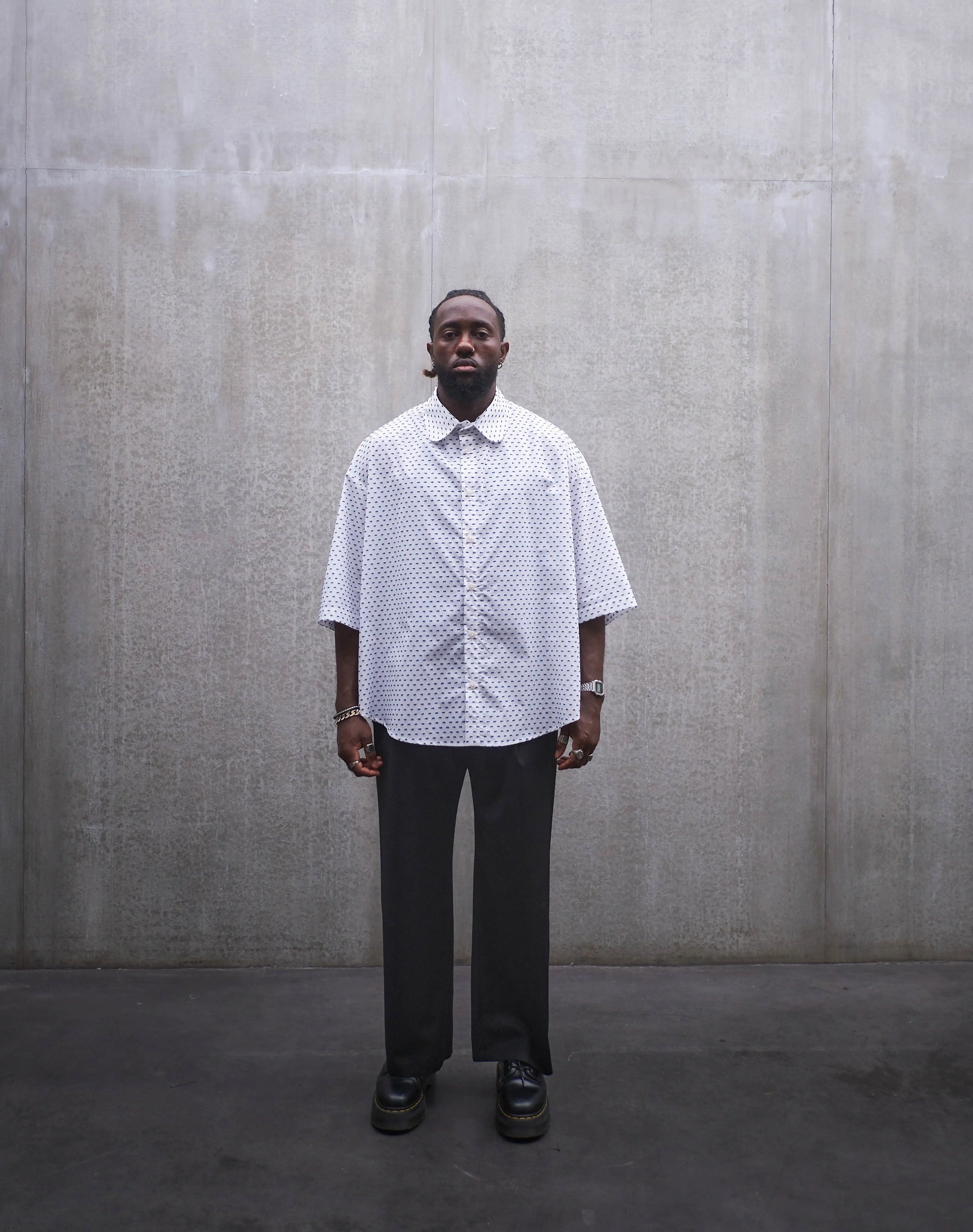 Chemise oversize à manches courtes et col club Aïdama modèle Marui en coton blanc à pois bleus. Portée par un mannequin homme et vue de face.
