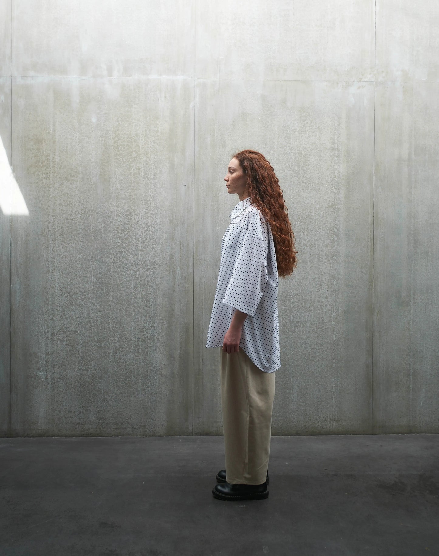 Chemise oversize à manches courtes et col club Aïdama modèle Marui en coton blanc à pois bleus. Portée par une mannequin femme et vue de profil.