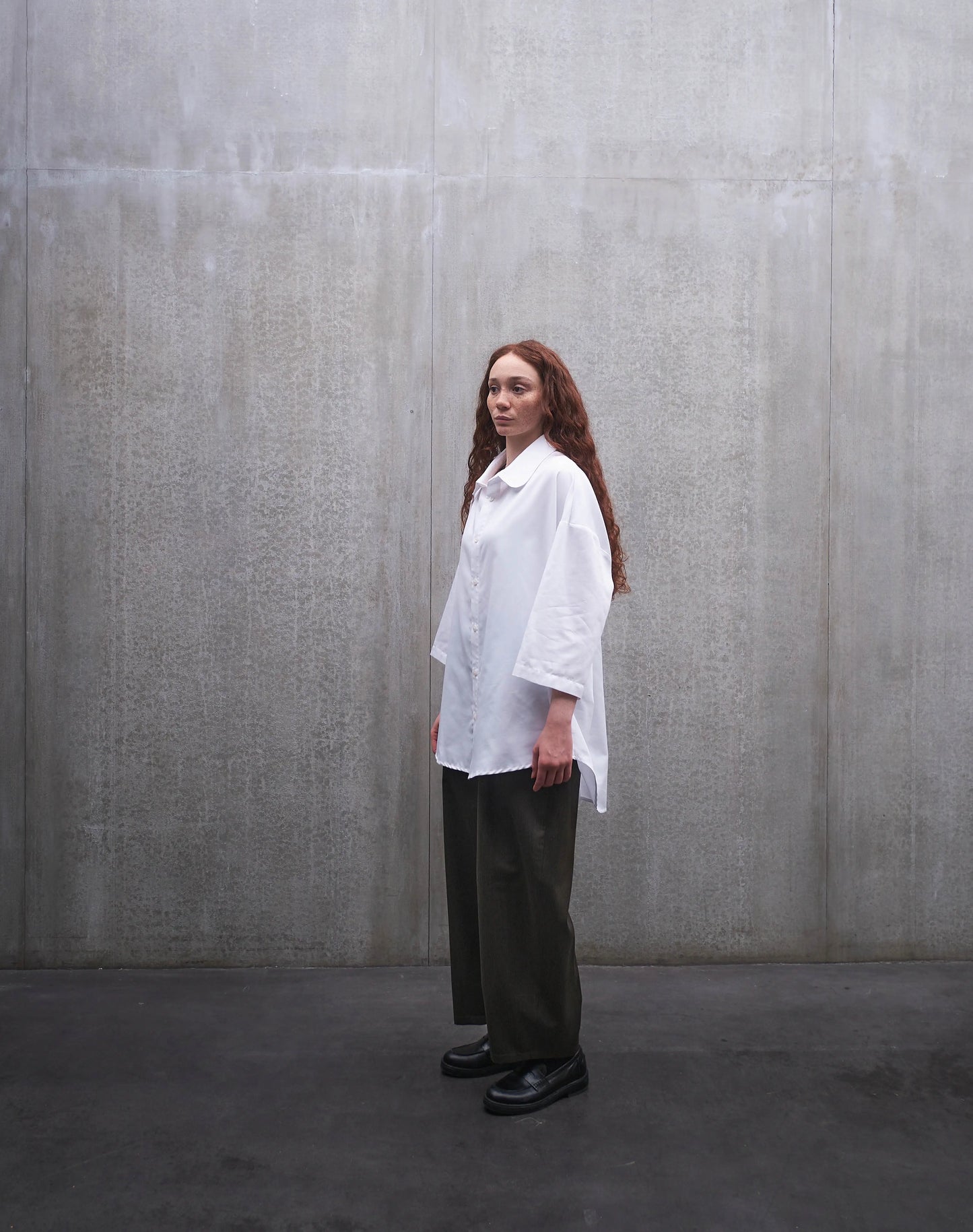 Chemise oversize à manches courtes et col club Aïdama modèle Marui en popeline de coton blanc. Portée par une mannequin femme et vue de profil.