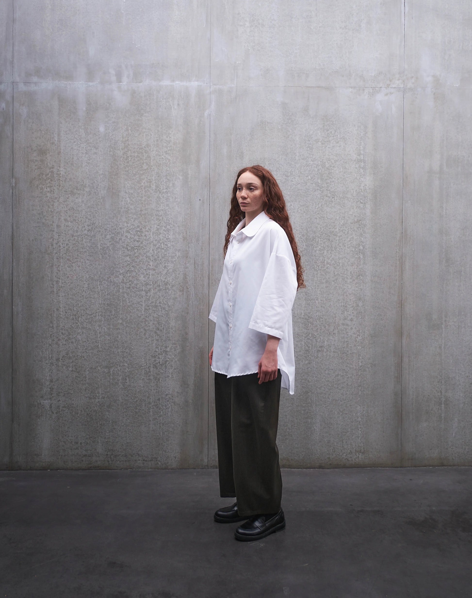 Chemise oversize à manches courtes et col club Aïdama modèle Marui en popeline de coton blanc. Portée par une mannequin femme et vue de profil.