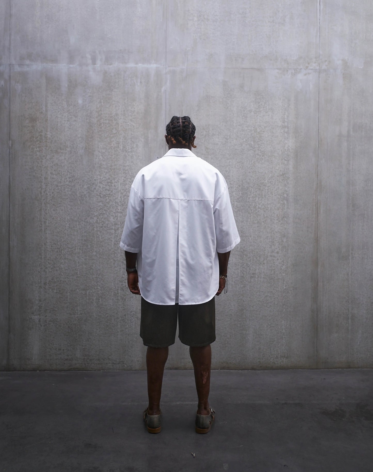 Chemise oversize à manches courtes et col club Aïdama modèle Marui en popeline de coton blanc. Portée par un mannequin homme et vue de dos.
