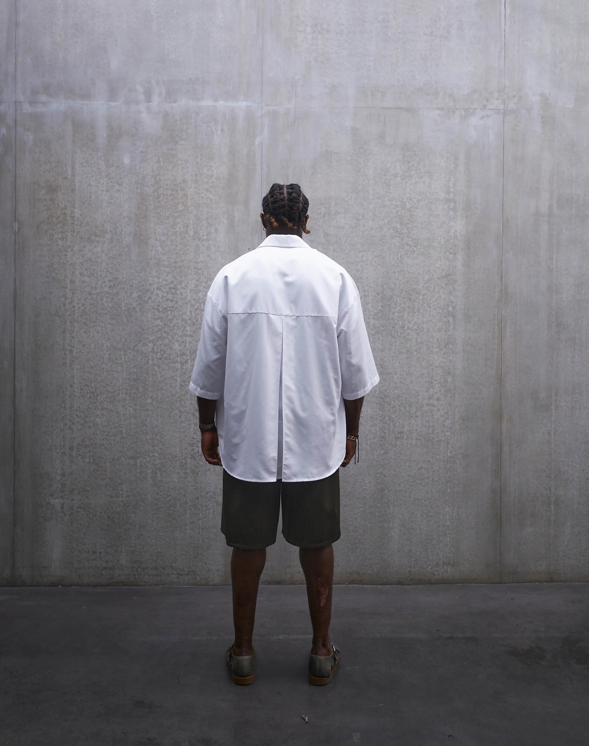 Chemise oversize à manches courtes et col club Aïdama modèle Marui en popeline de coton blanc. Portée par un mannequin homme et vue de dos.