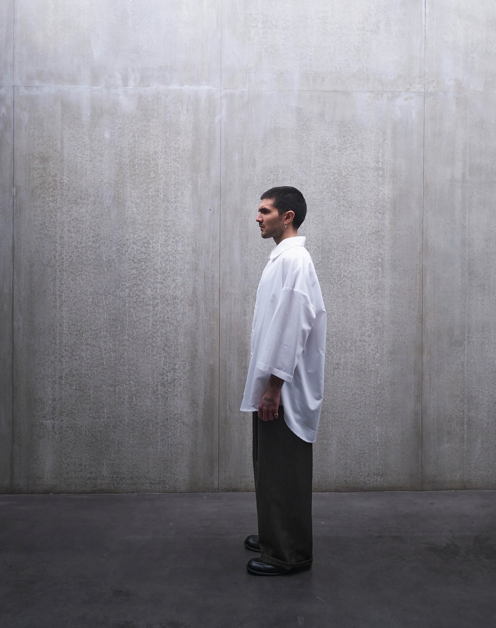 Chemise oversize à manches courtes et col club Aïdama modèle Marui en popeline de coton blanc. Portée par un mannequin homme et vue de profil.