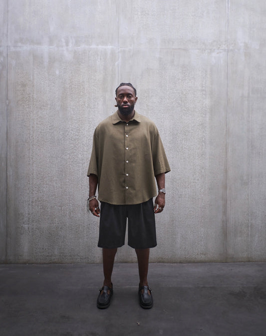 Chemise oversize à manches courtes et col club Aïdama modèle Marui en coton vert chiné. Portée par un mannequin homme et vue de face.
